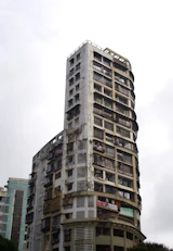 A worn apartment tower against a bright sky