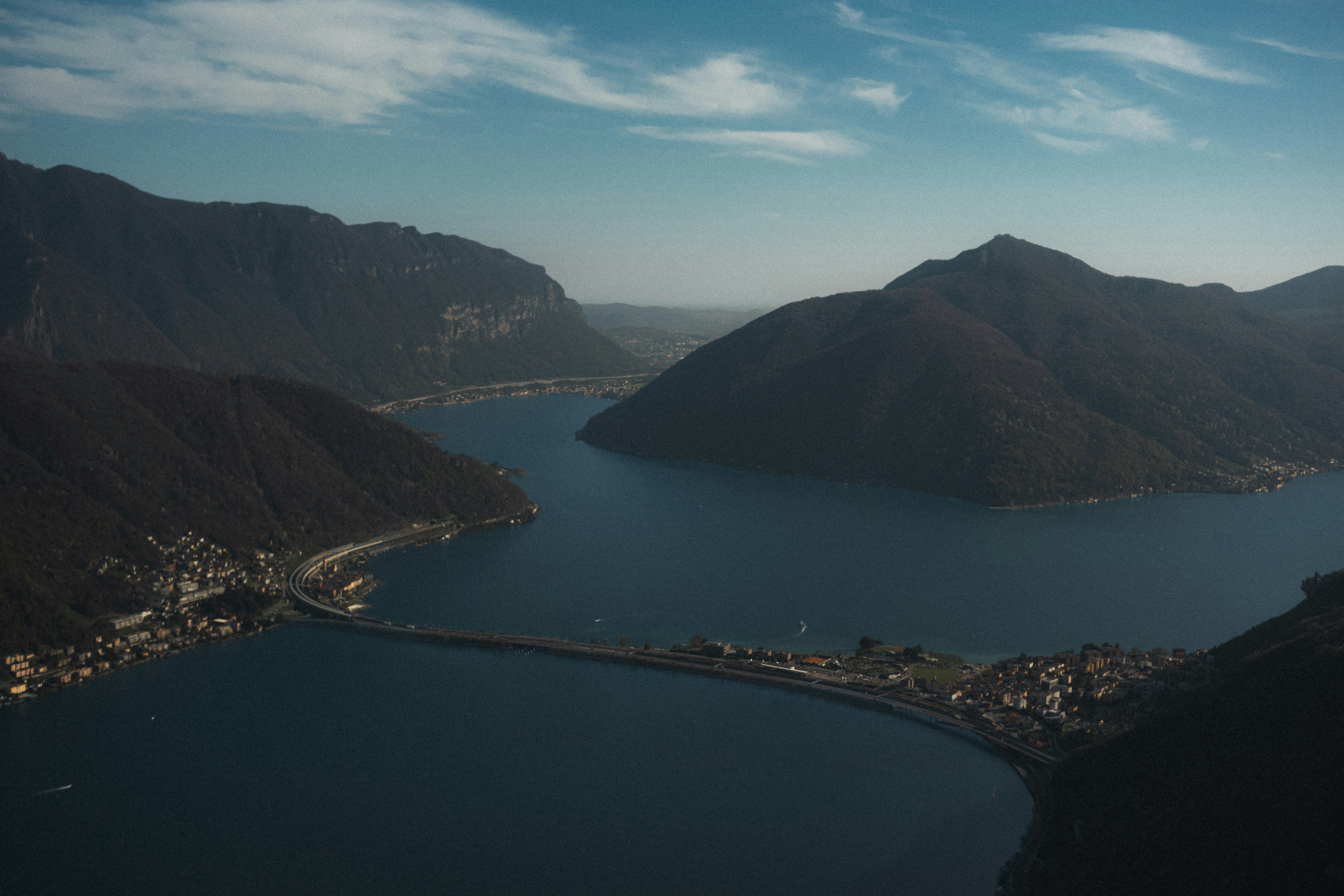 A scenic lake with a bridge connecting two mountainous shores