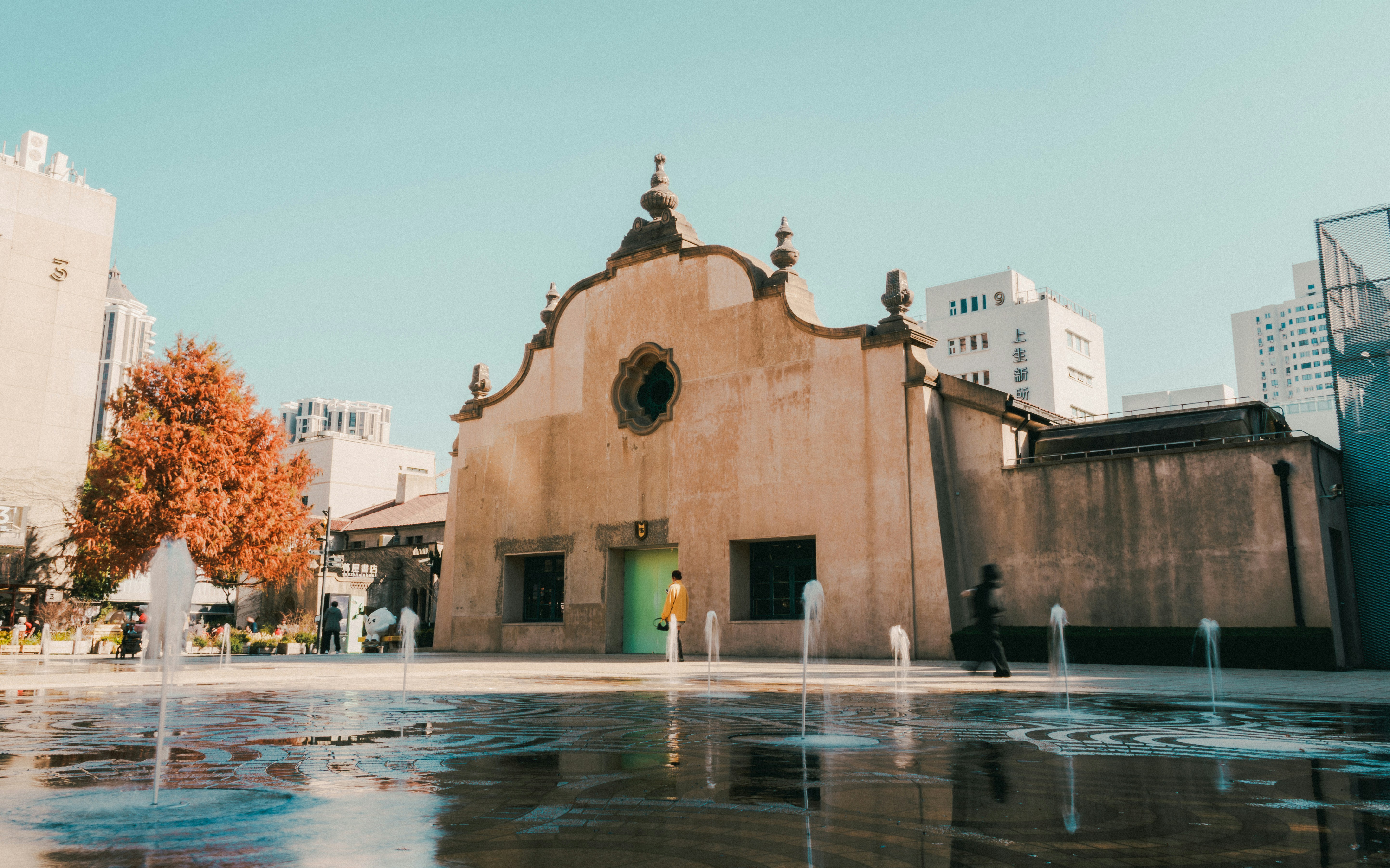 Historic building with fountains and people in a sunny plaza