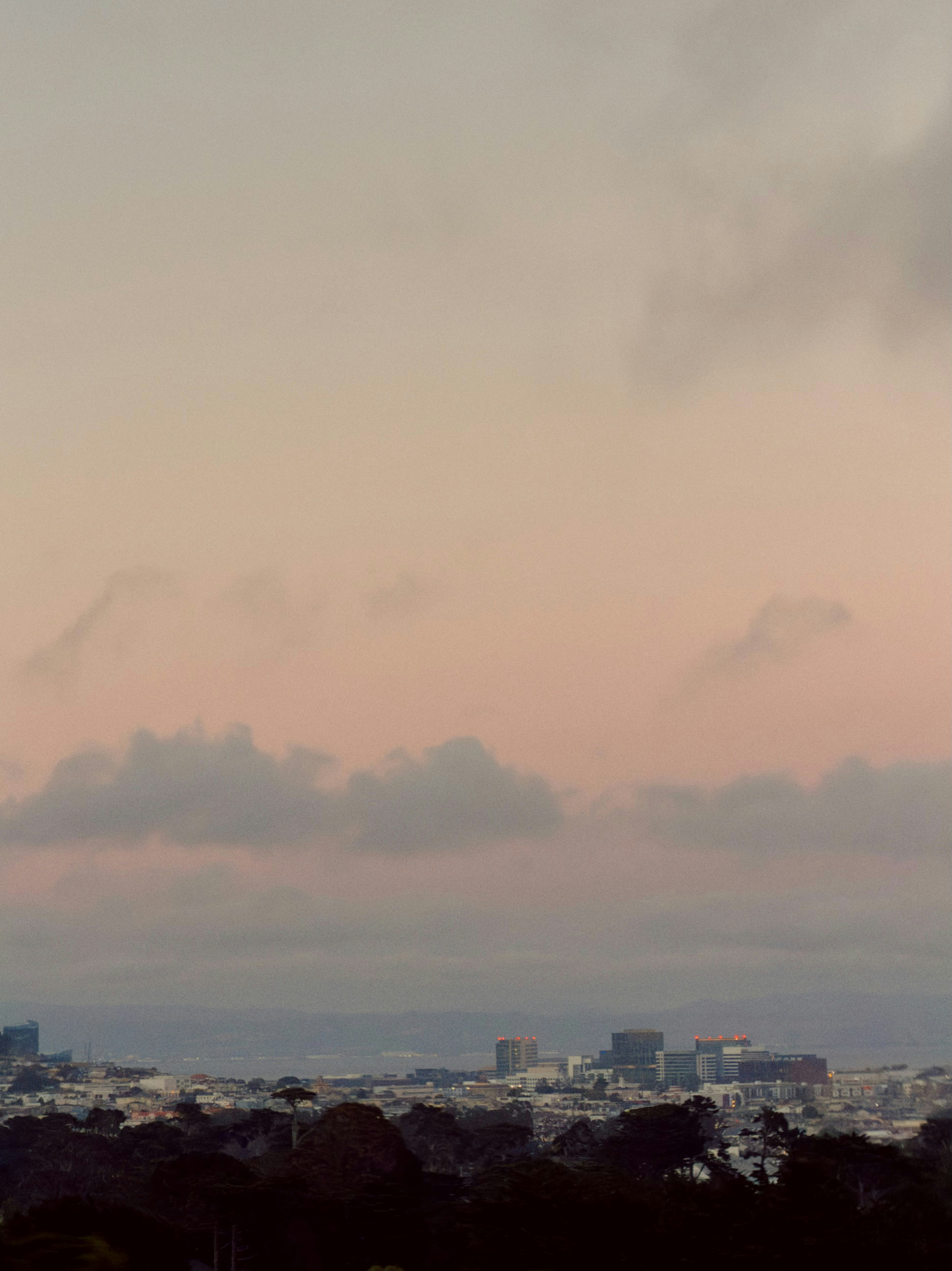 Cityscape at dusk with pink sky and clouds