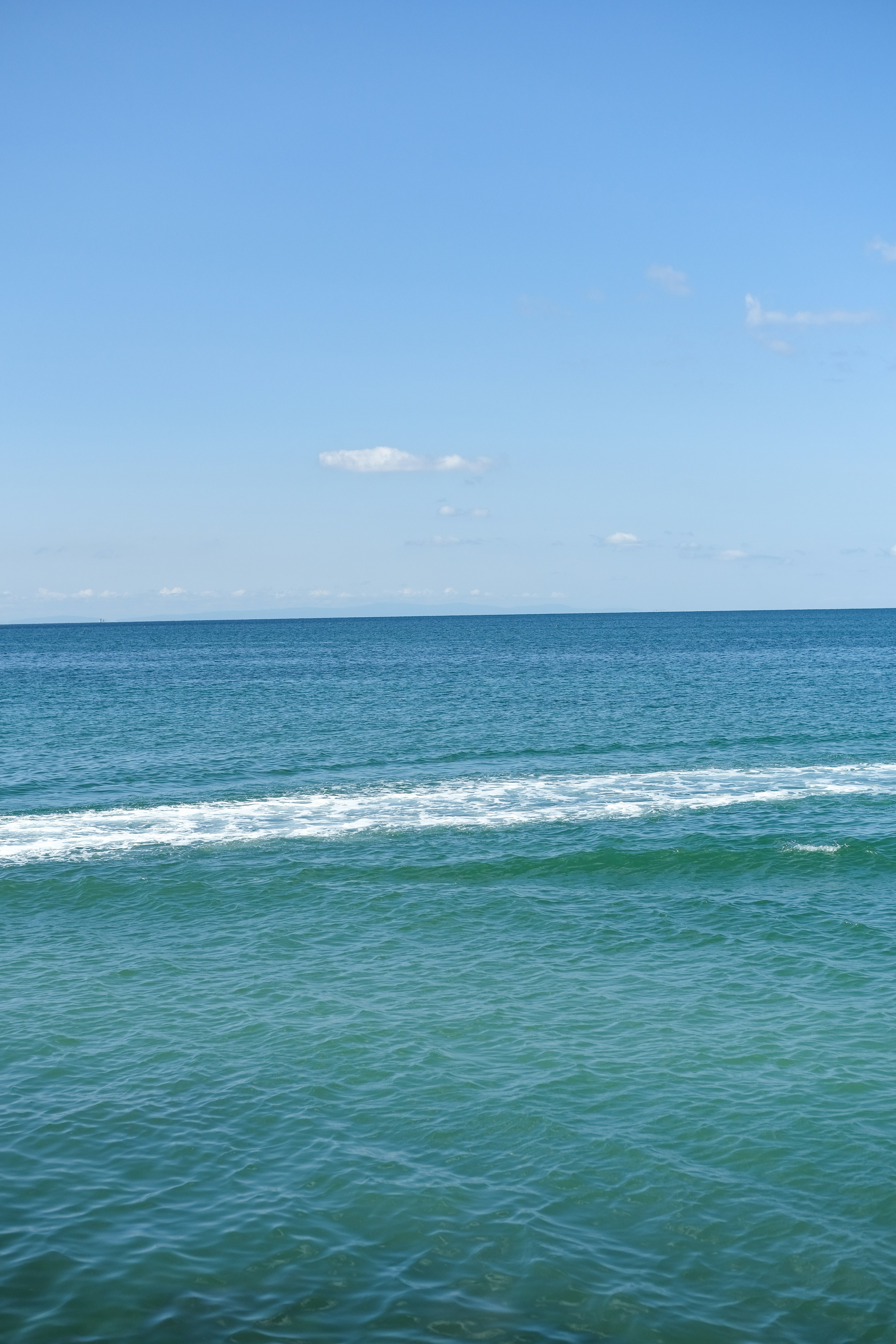 océan bleu, vague blanche et ciel clair
