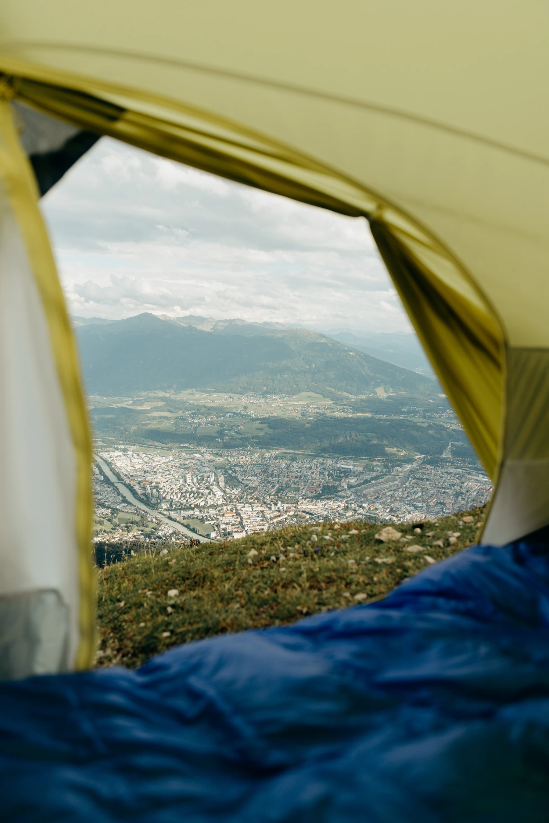 Sleeping bag arranged inside a camping tent overlooking the outdoors