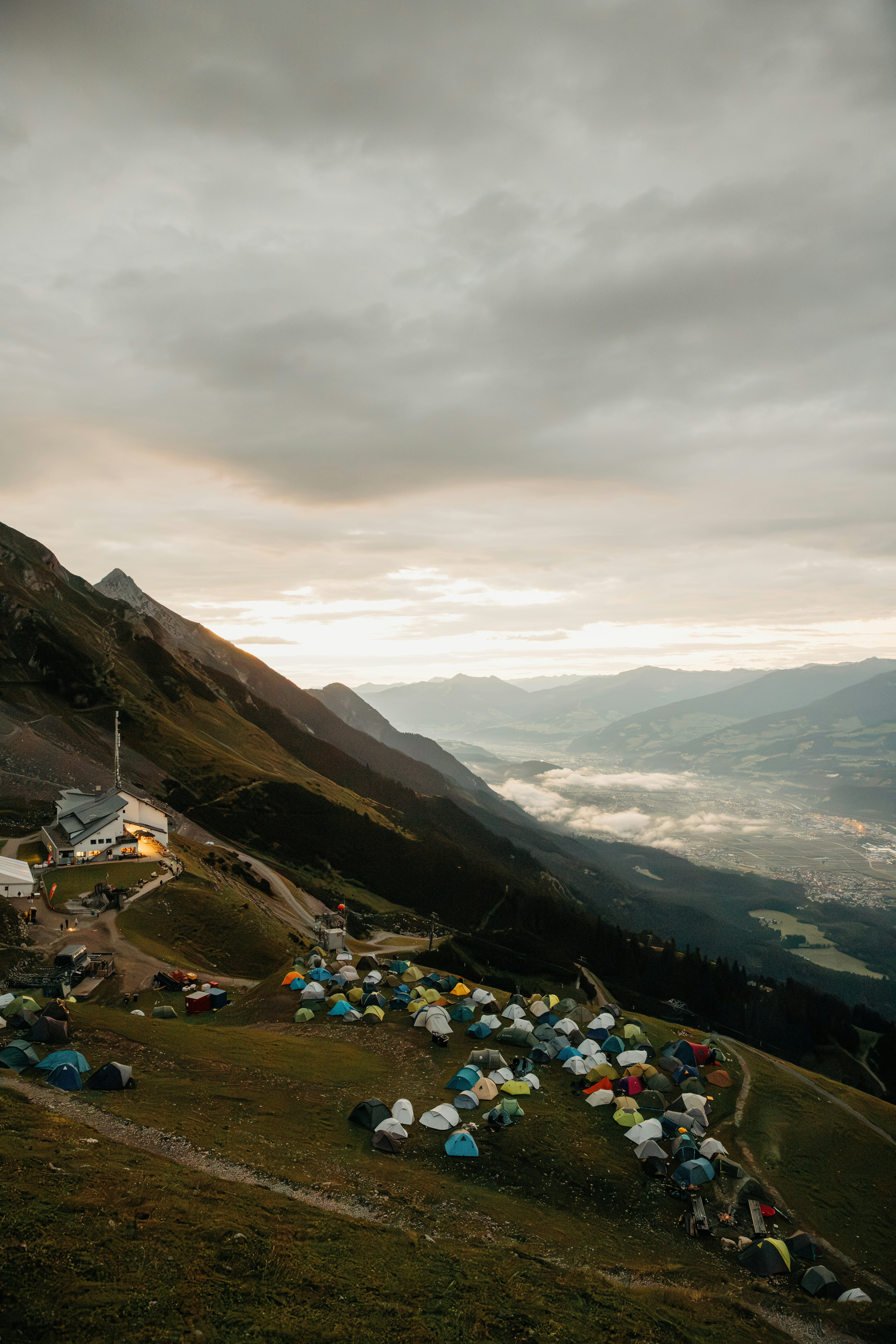 Mountain landscape with a campsite and distant valley at dawn.