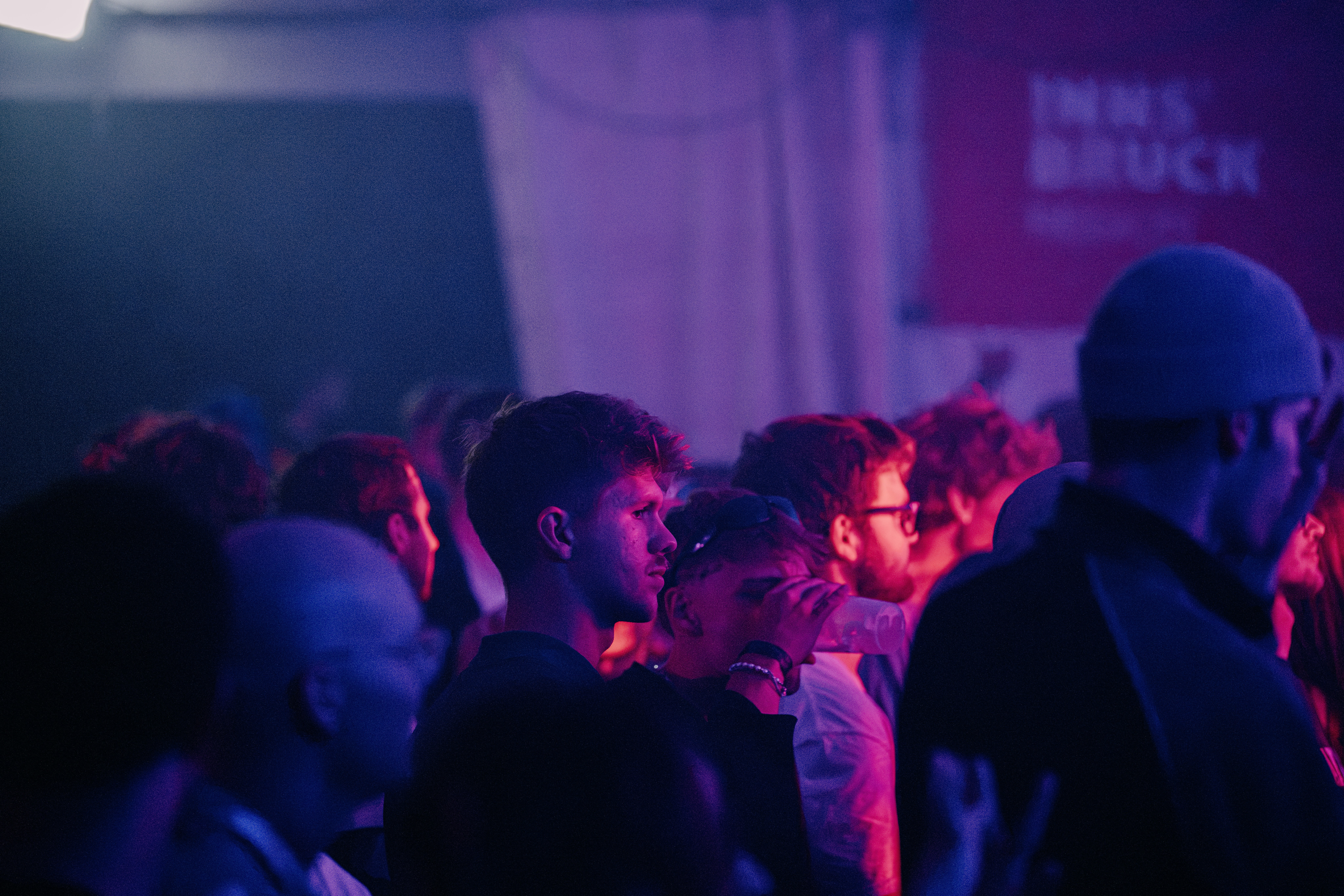 People gathered in a dim, purple-lit indoor event