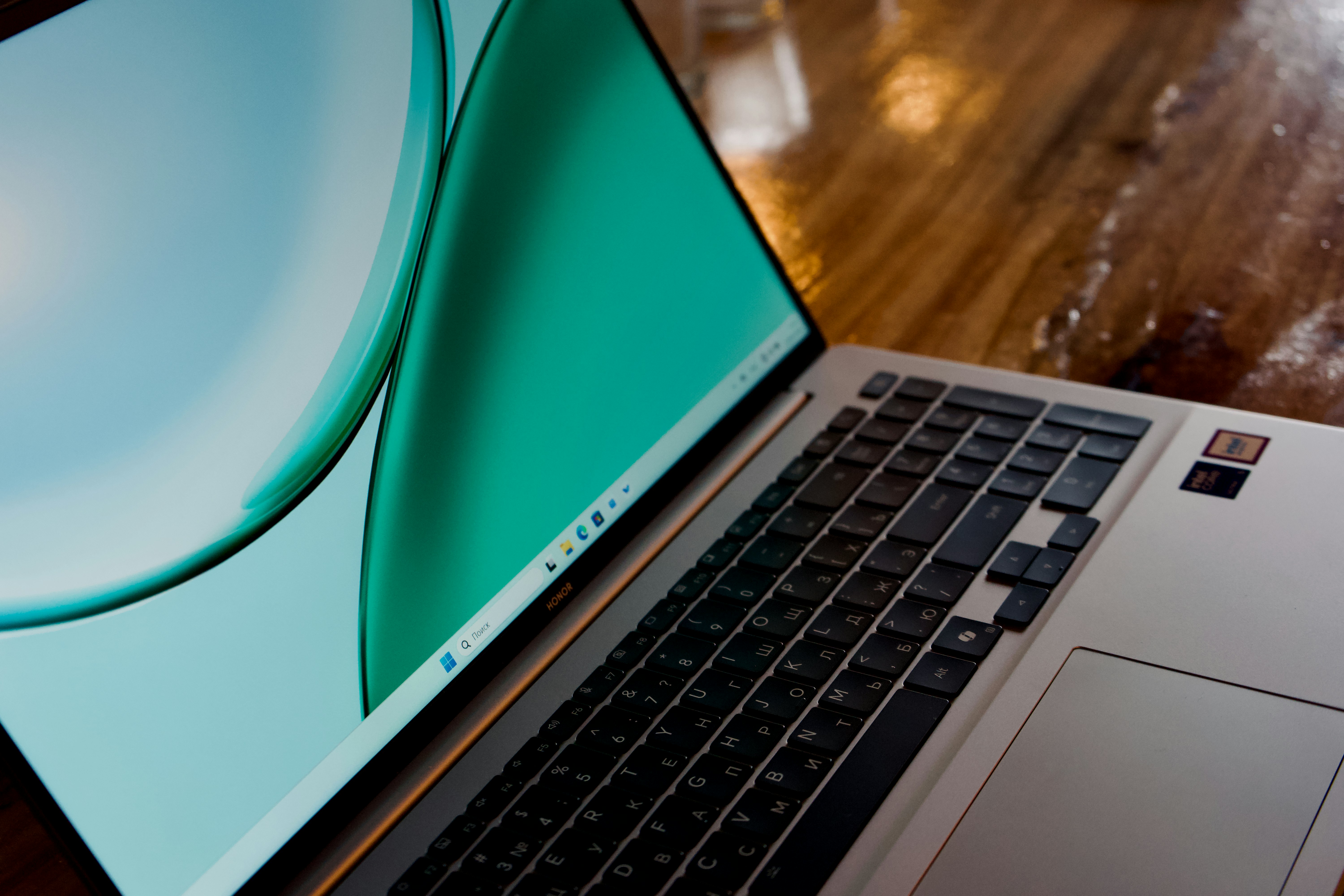 Laptop with green screen on a wooden desk.