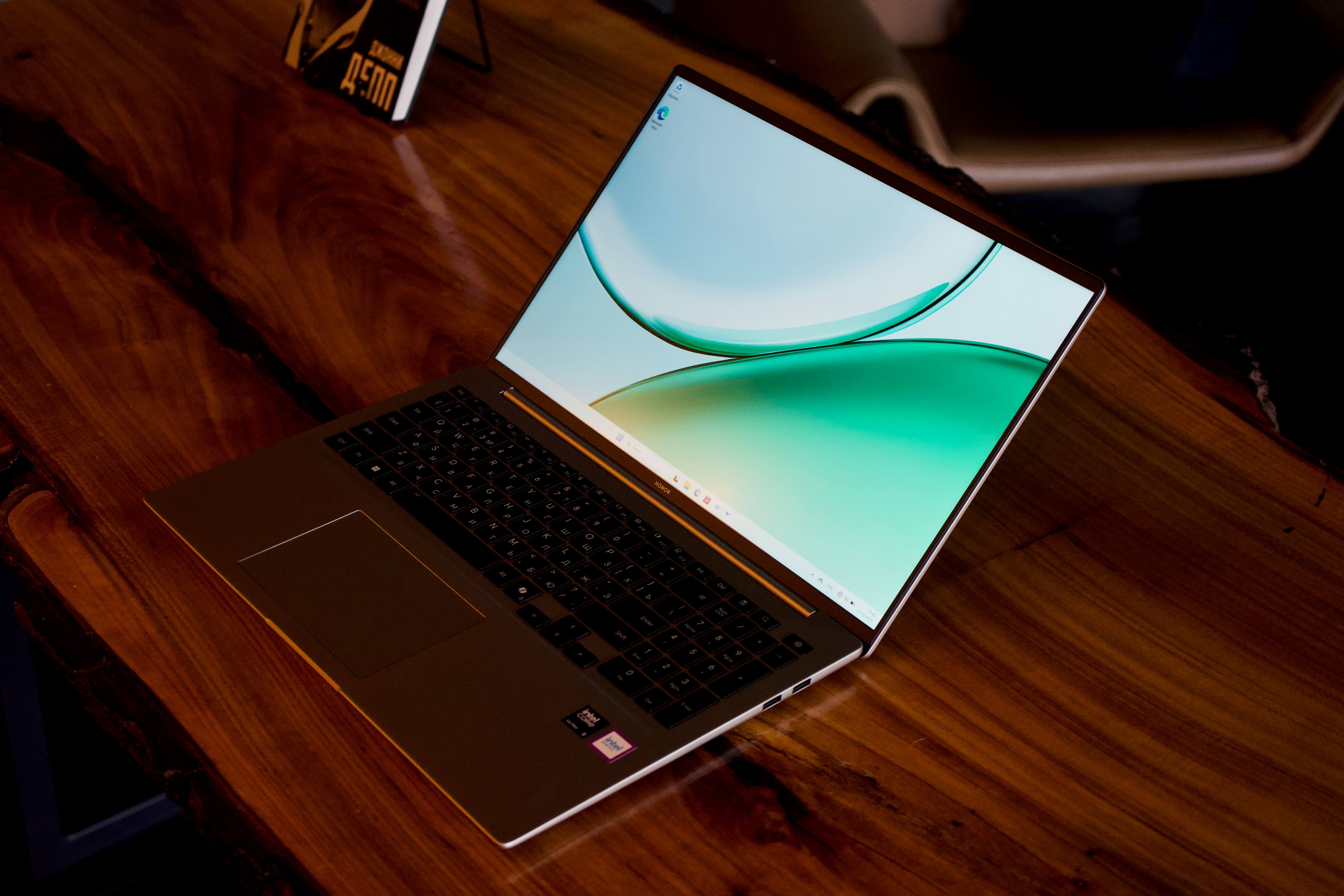 A sleek laptop open on a glossy wooden table.