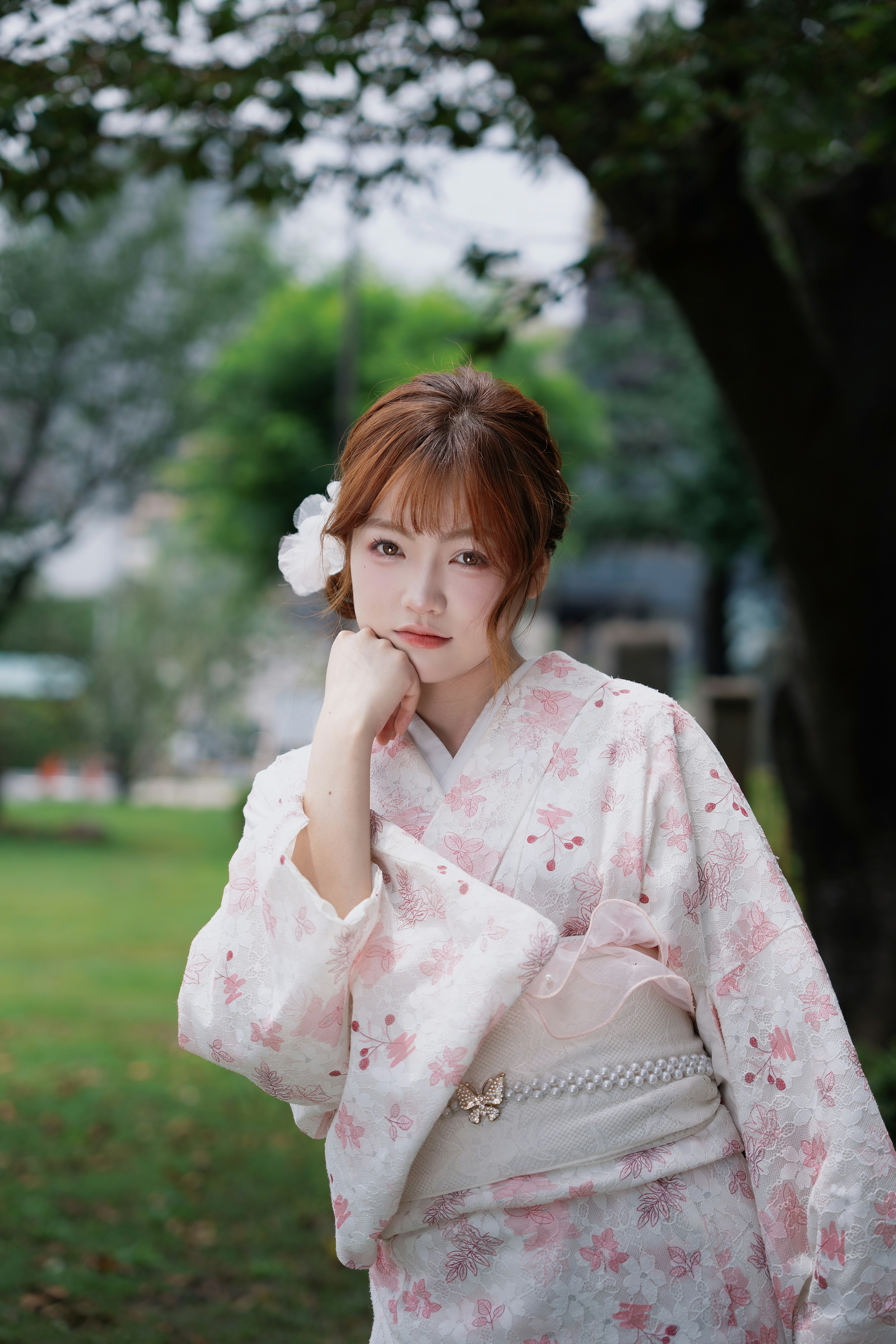 아름다운 꽃무늬 기모노를 입은 젊은 여성이 야외에 서 있다
