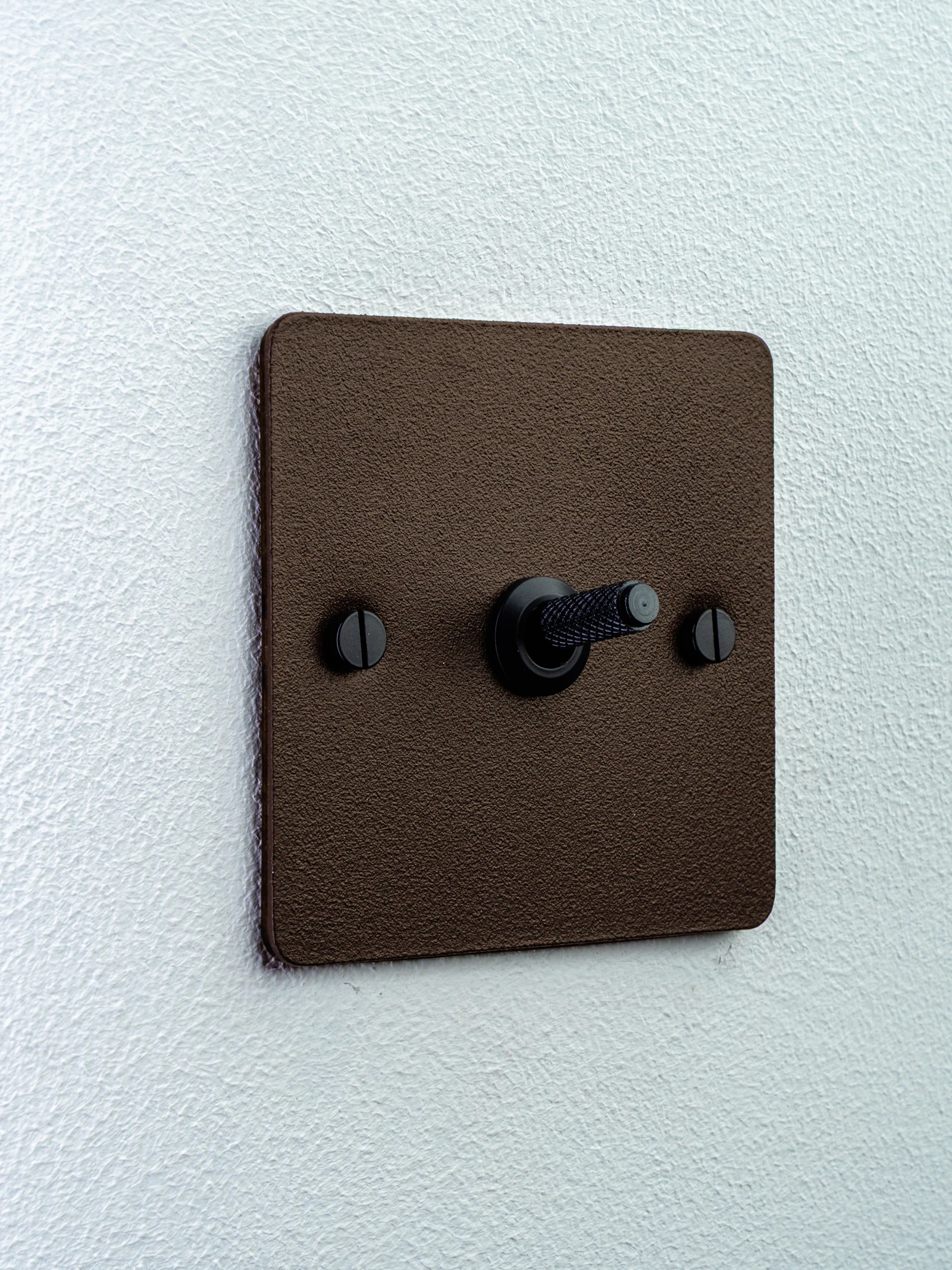 Warm-toned toggle light switch on a white wall