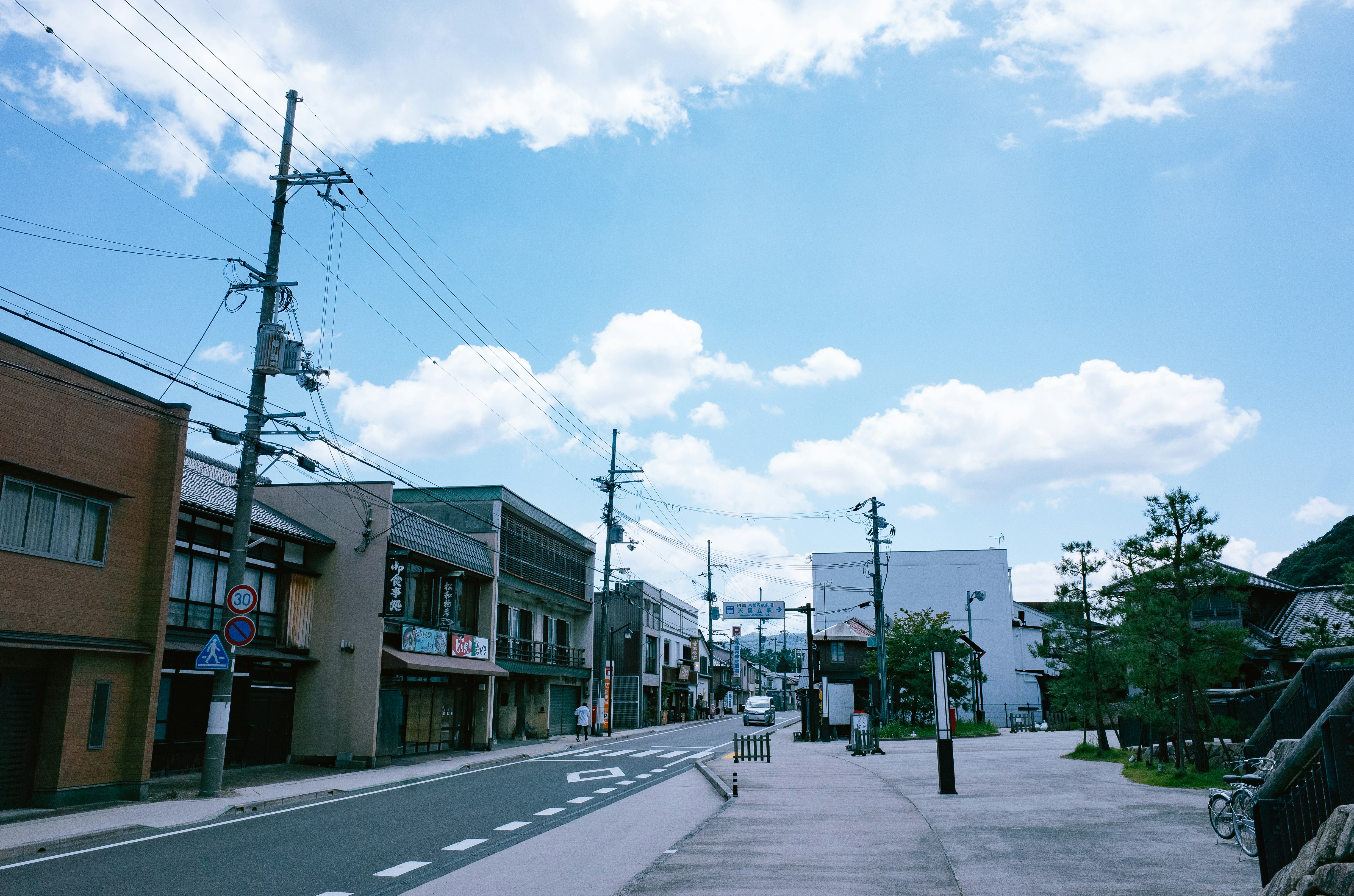 A quiet street lined with low wooden buildings in one of Kyoto's older quarters, the kind of streetscape that still shapes Fushimi's brewery district away from the main tourist routes