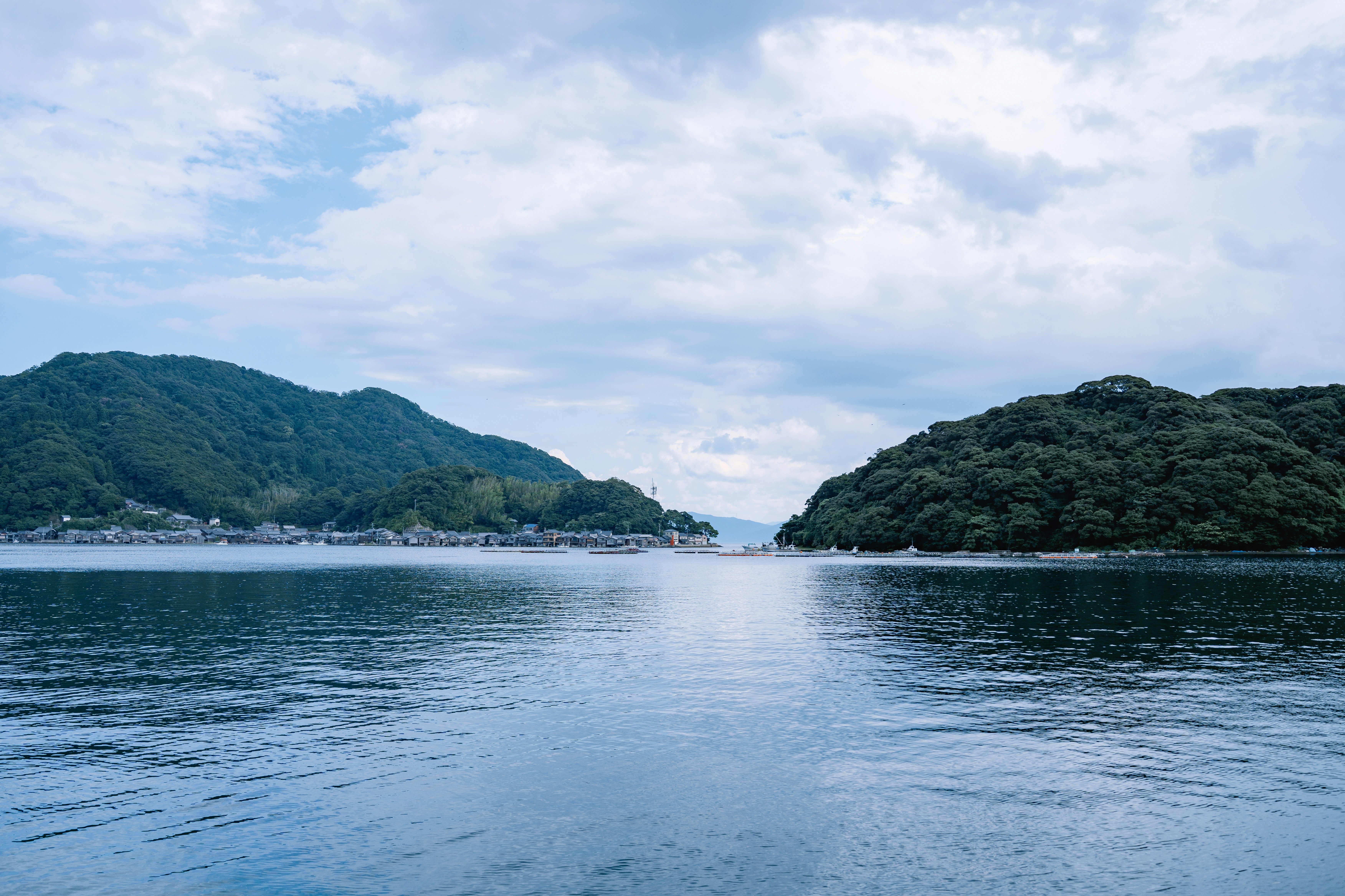 Calm blue water between two green, forested islands