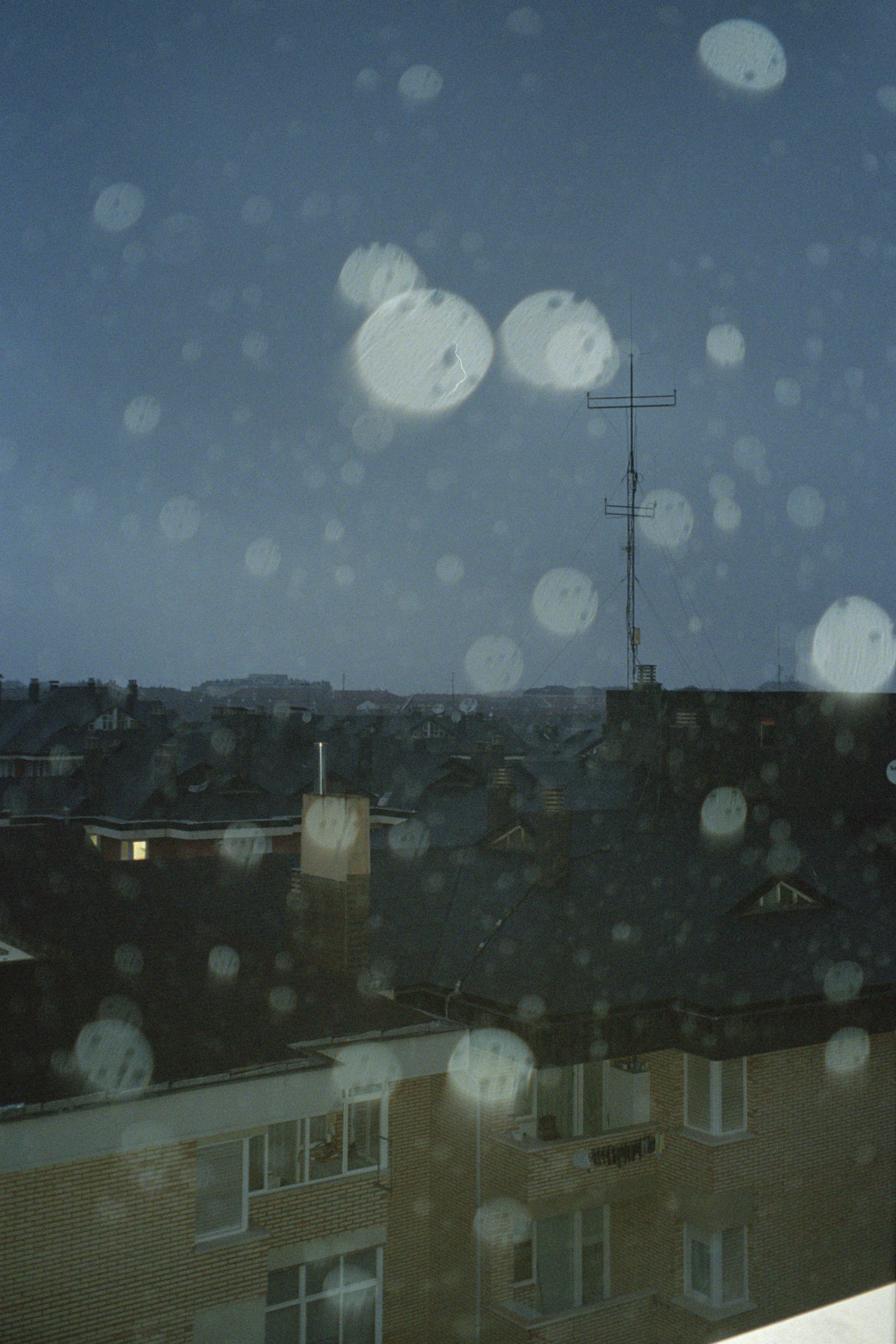 City view through a rainy window with bokeh lights
