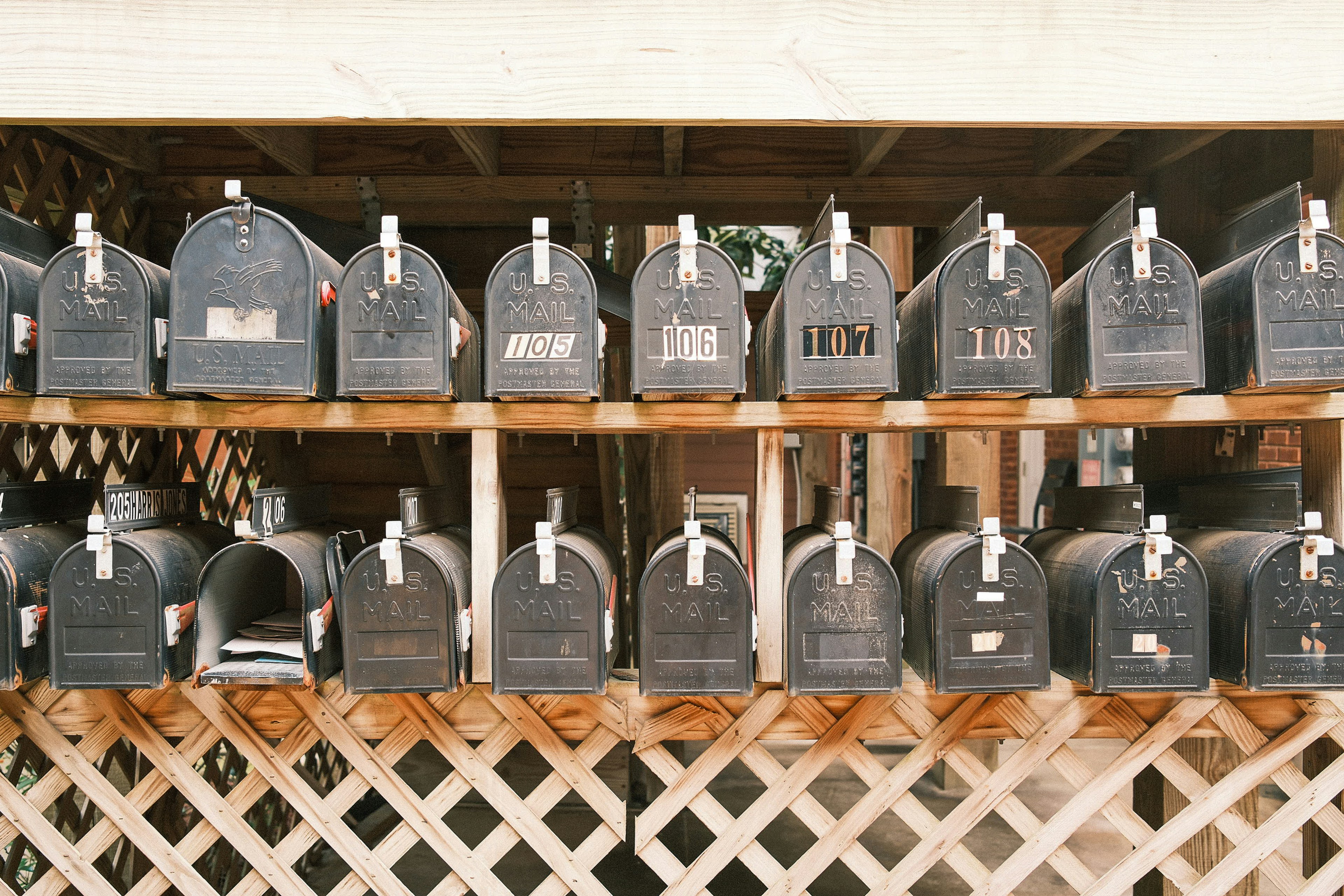 Rows of old black mailboxes on wooden shelves