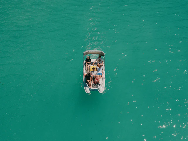 Overhead view of a boat carrying a group across bright turquoise water