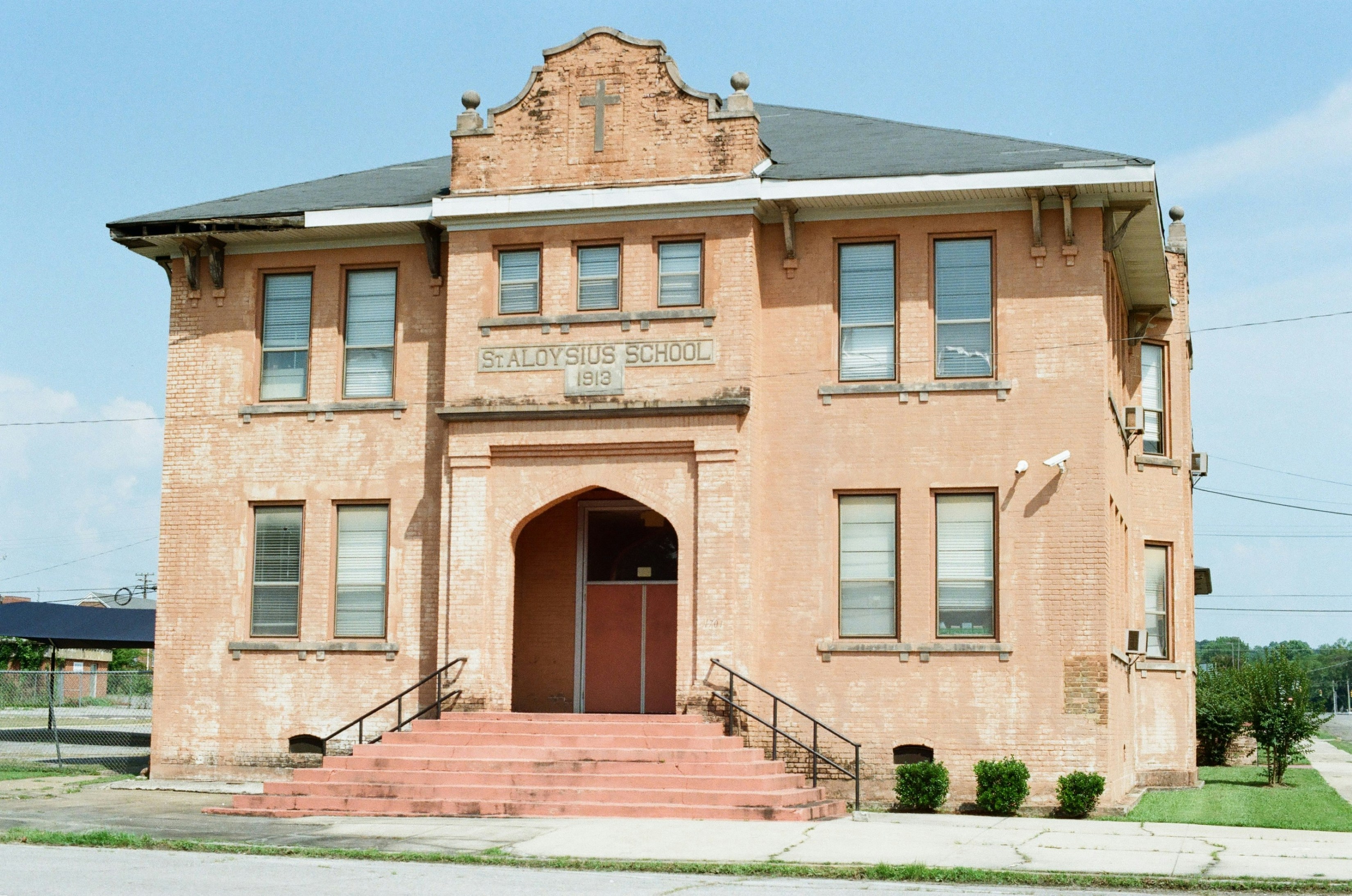 An old peach-colored community hall building with red steps.