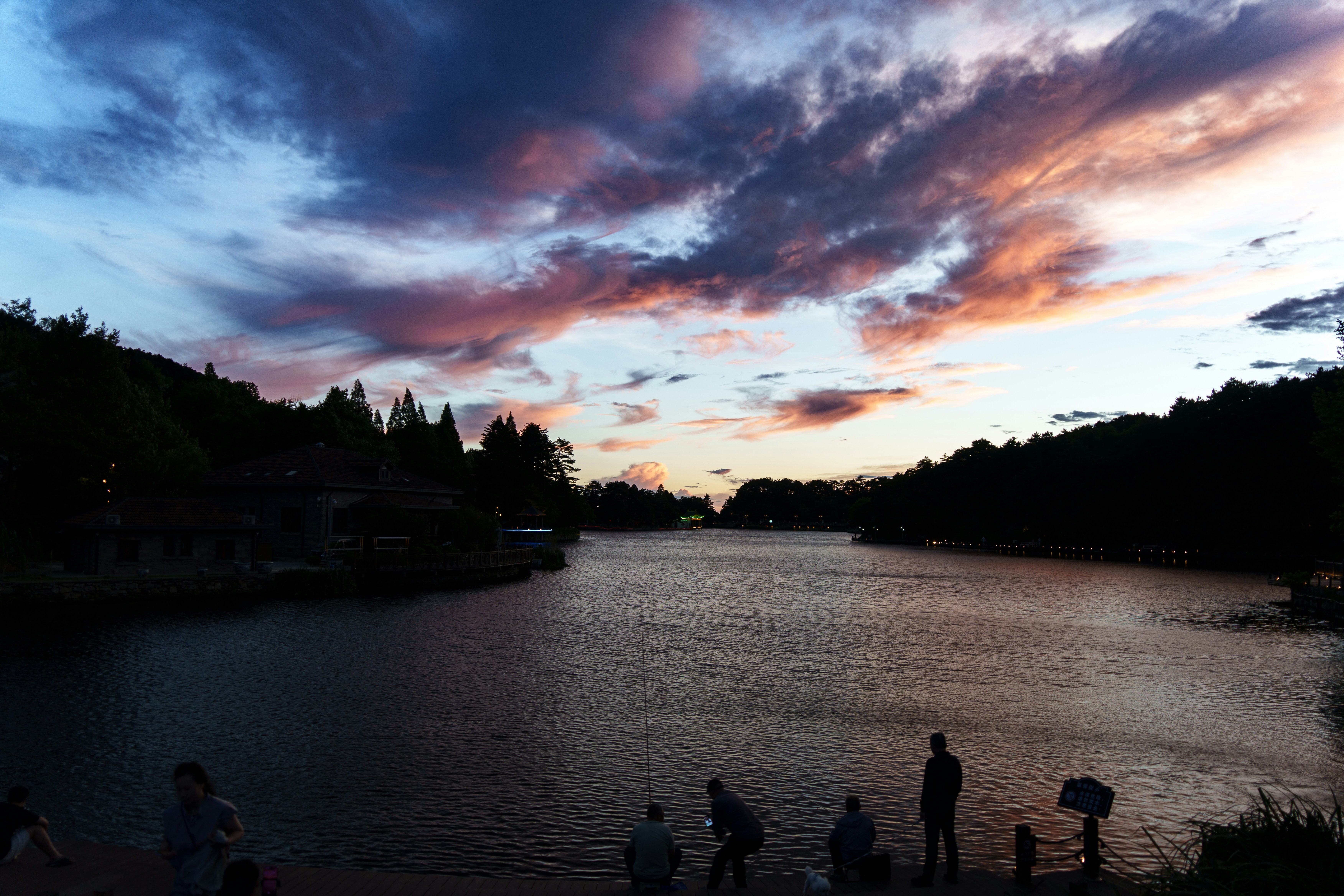 Colorful sunset over a lake with people on the shore