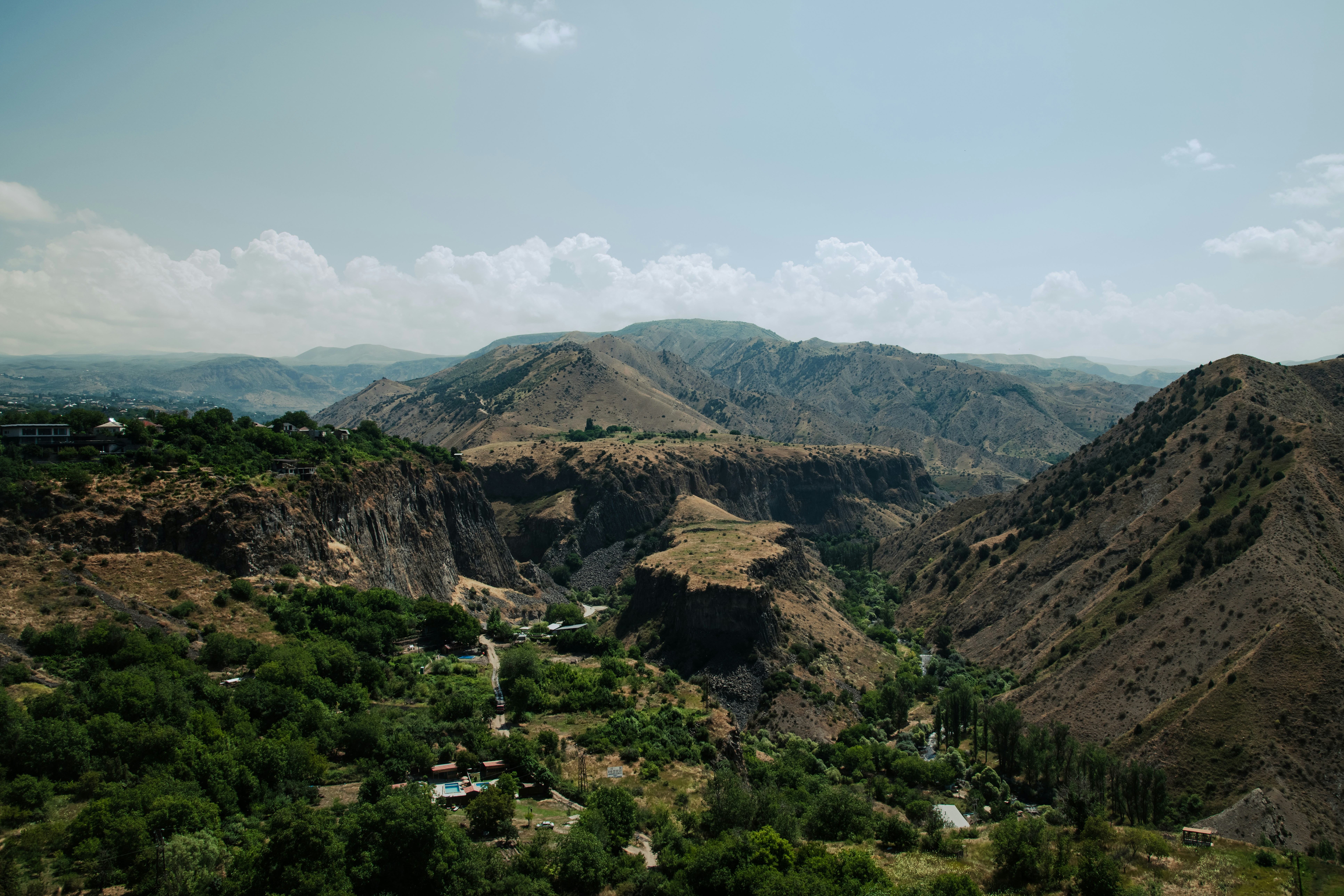Vale verde aninhado em uma vasta paisagem montanhosa.