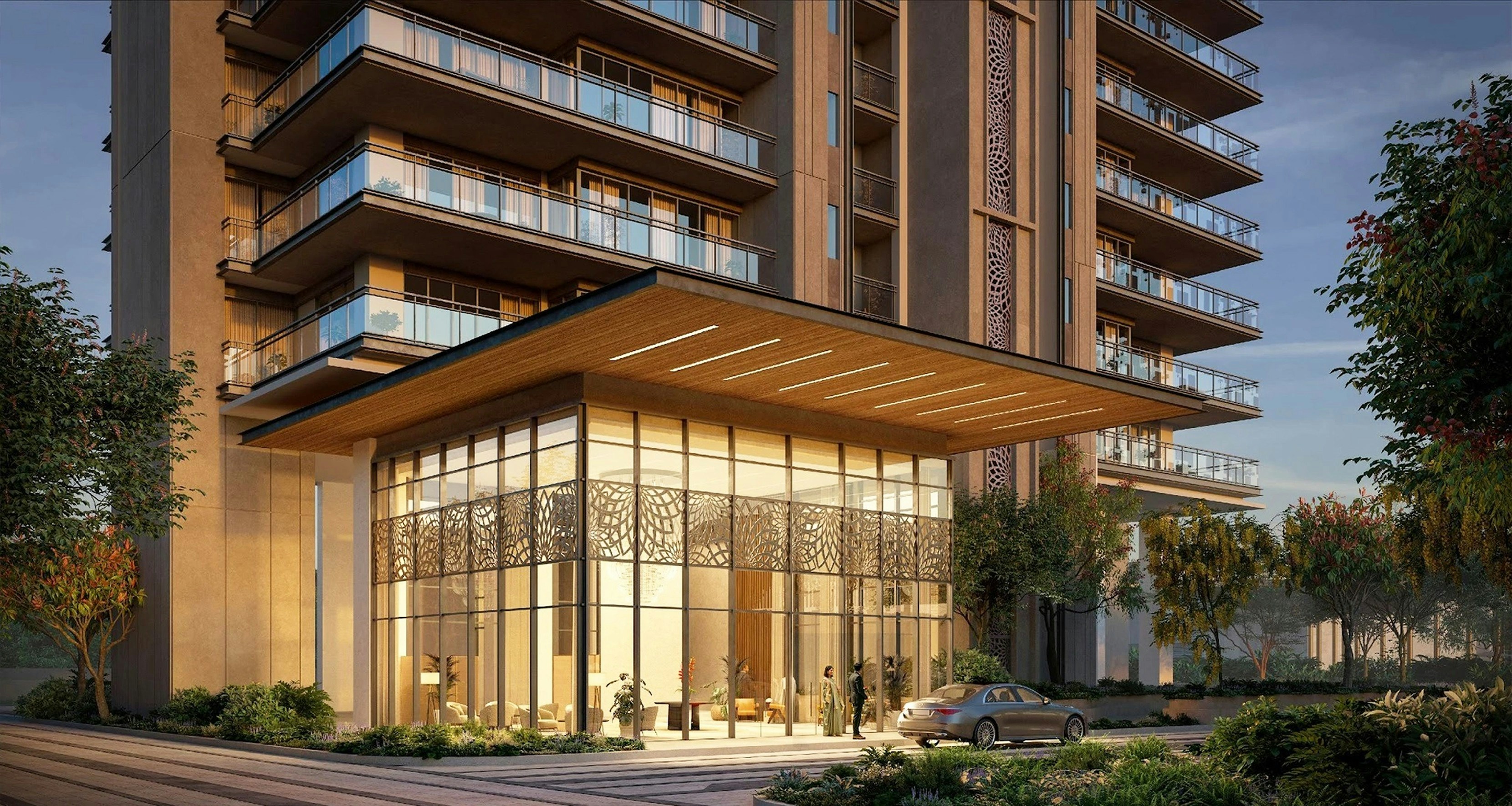 Modern building entrance with glass facade and balconies at sunset