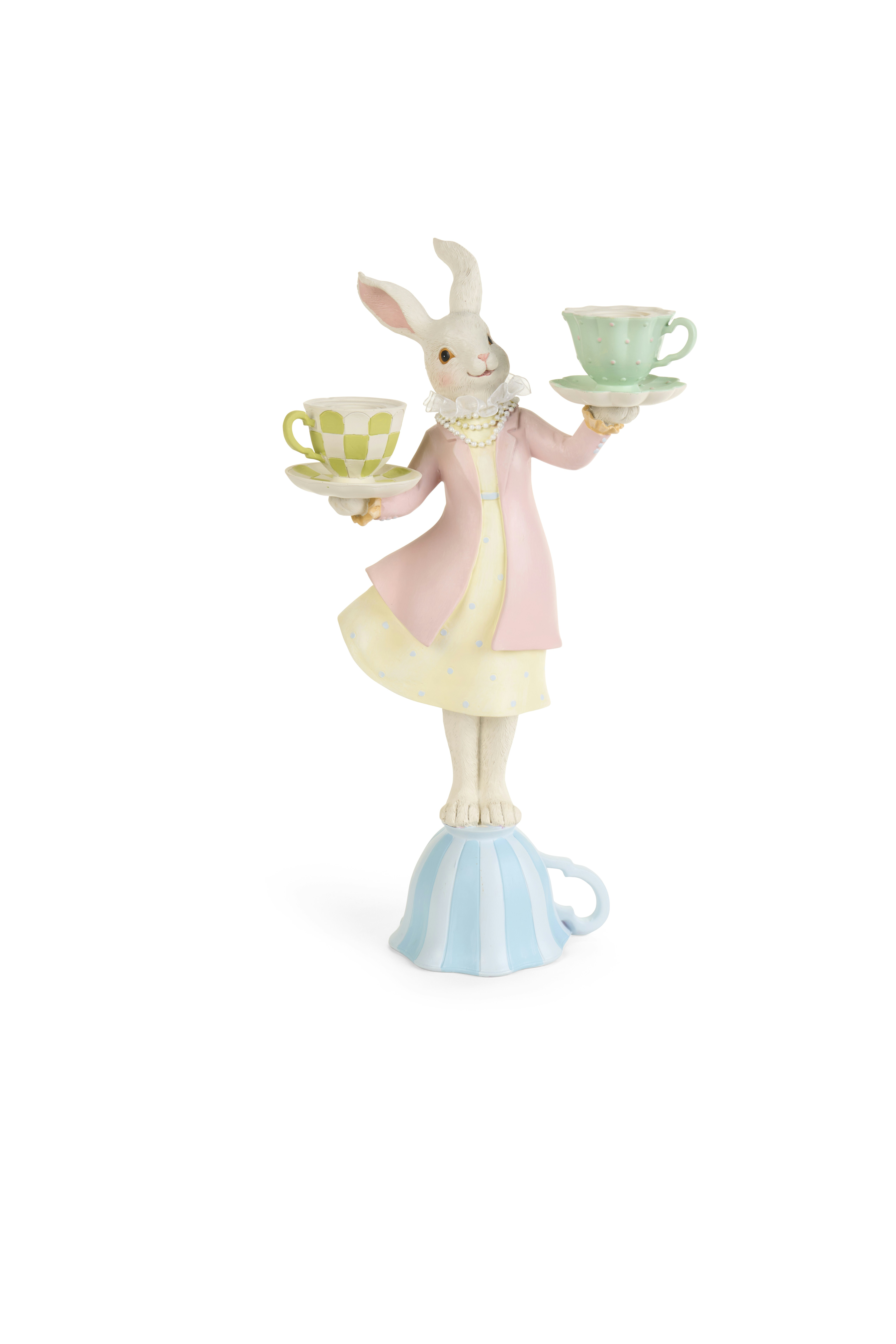 A rabbit figurine balancing on a teacup, holding two teacups