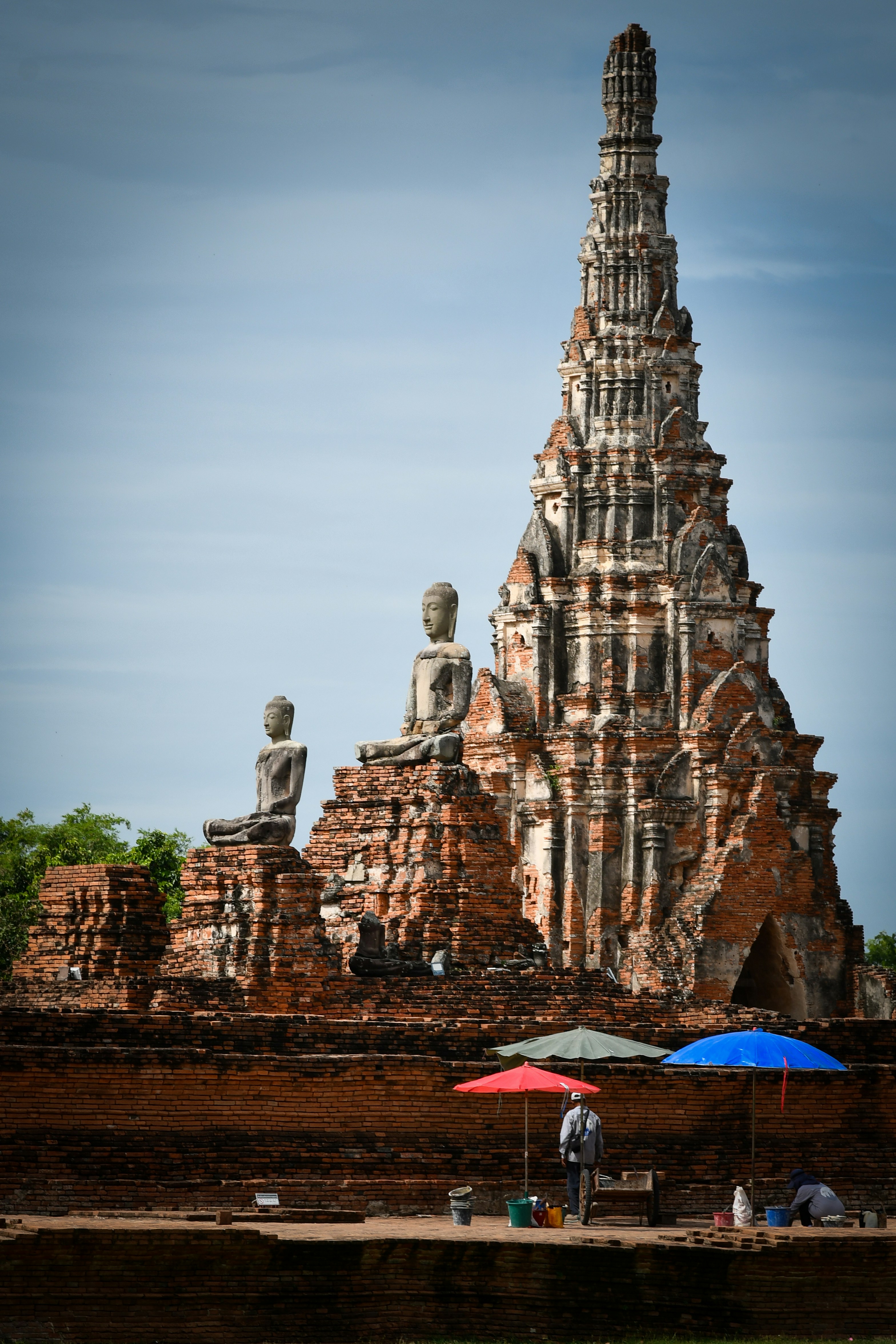 Towering ancient temple ruins with seated buddha statues.