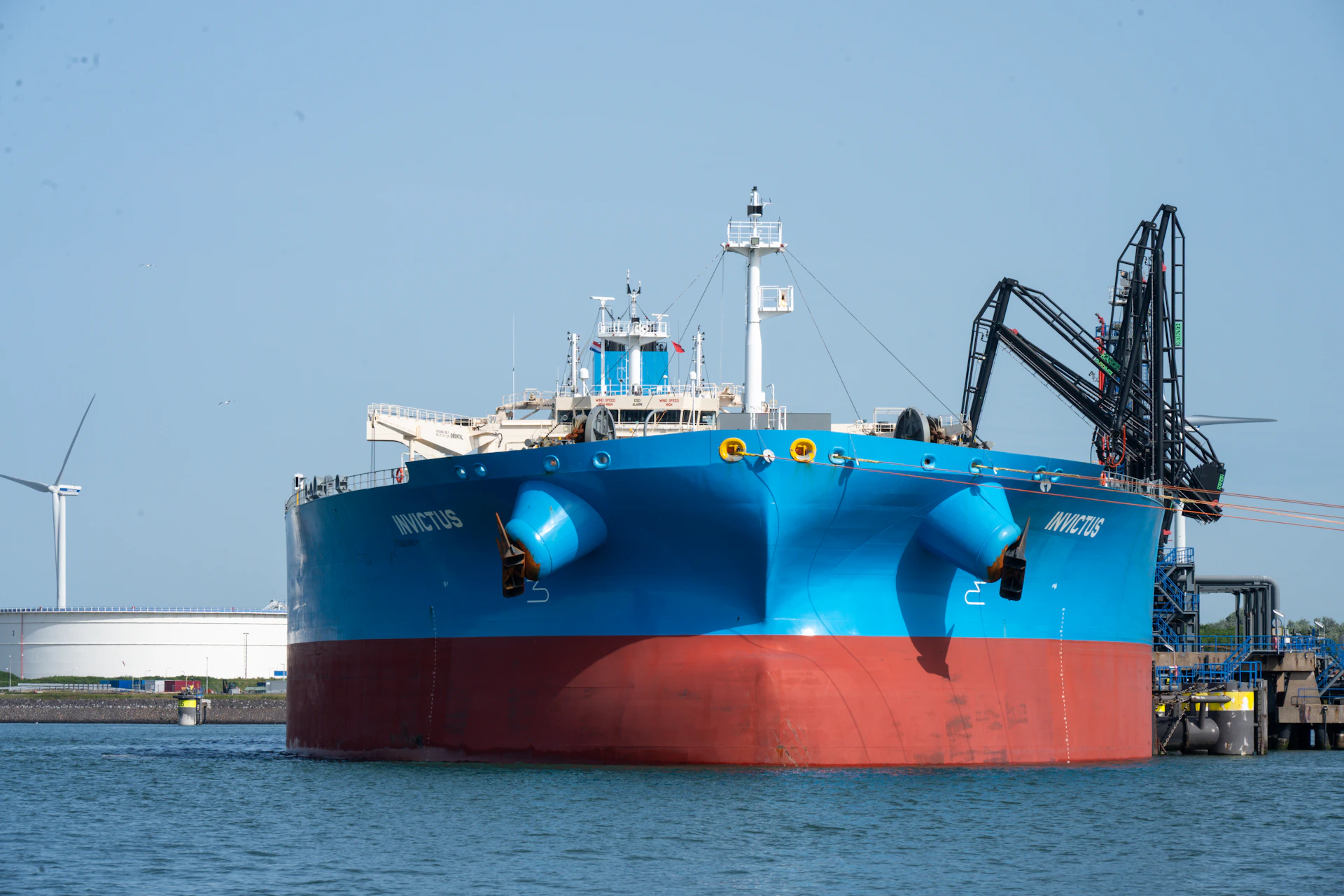 Large blue and red ship docked in harbor