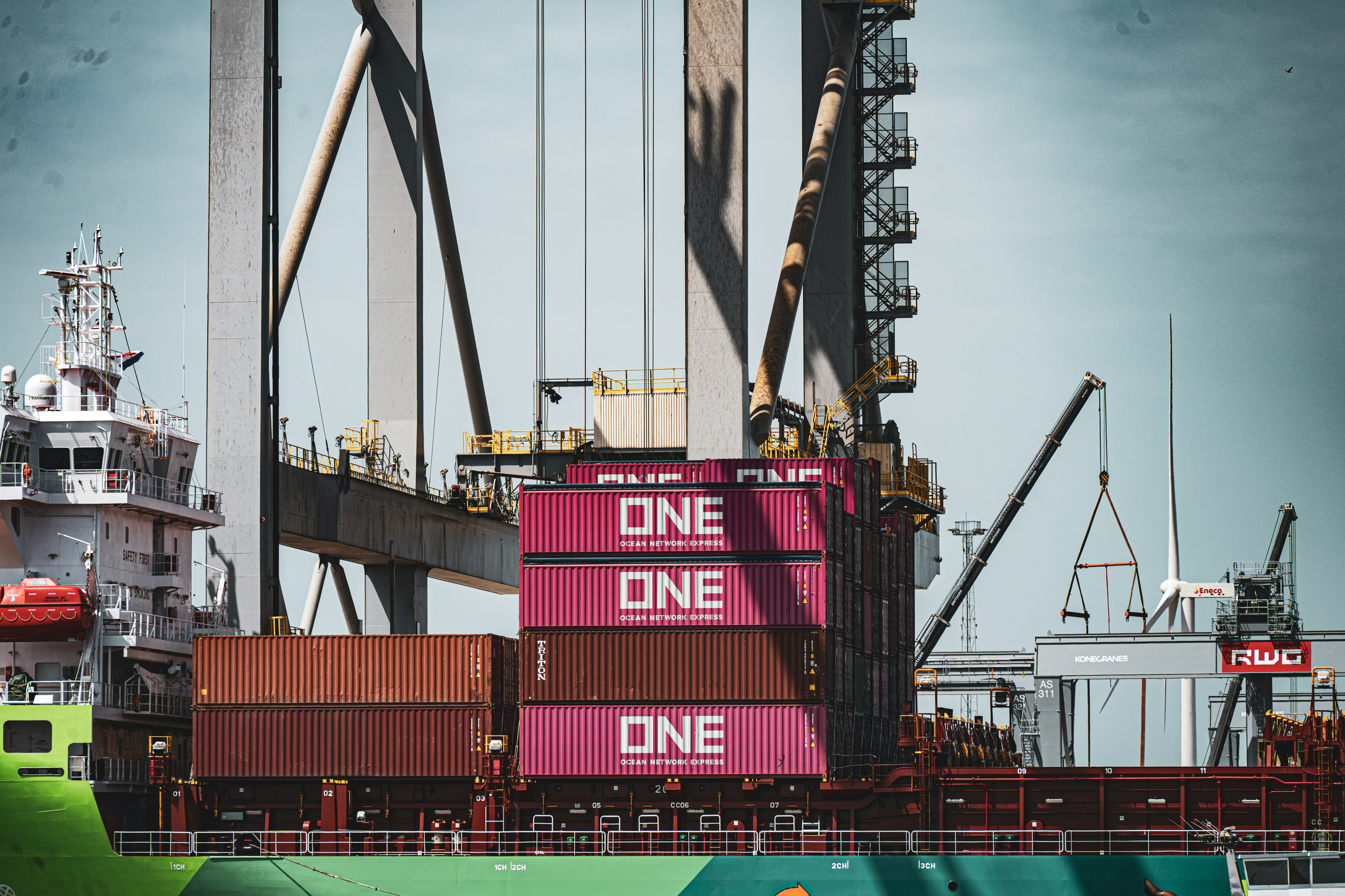 Train with pink containers at a busy shipping port