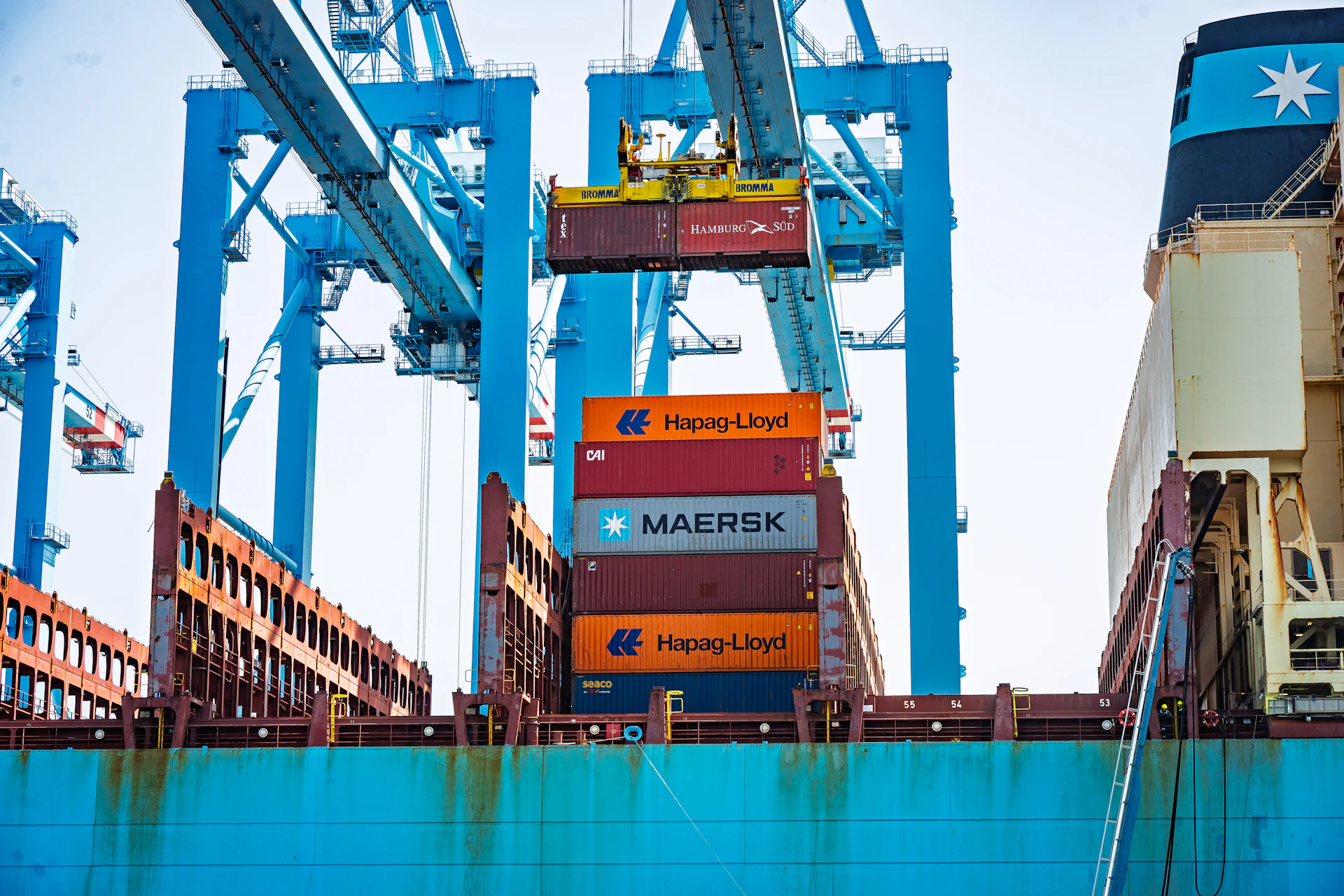 Port cranes loading shipping containers onto a large cargo ship