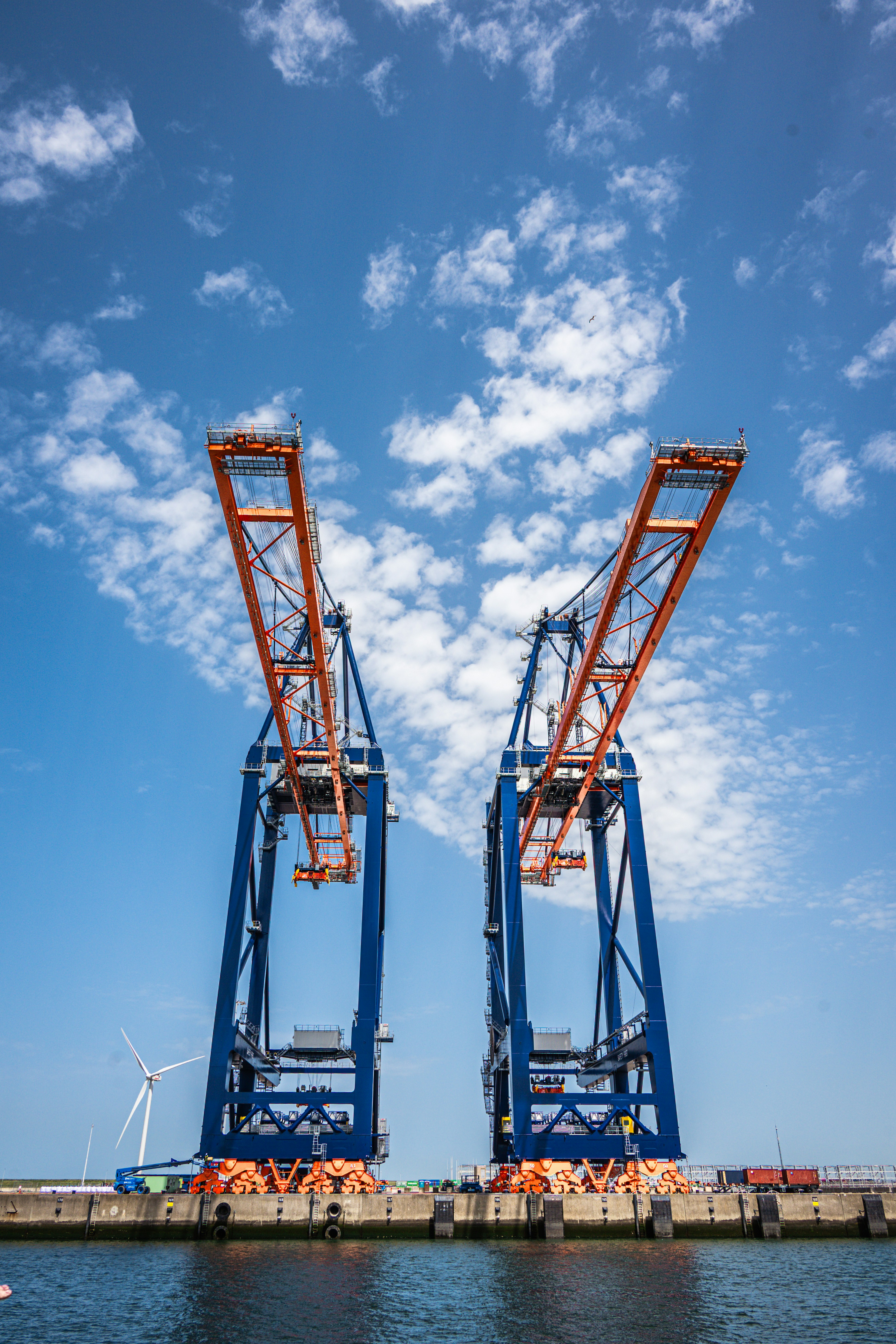 Grúas de contenedores en un puerto industrial bajo un cielo azul