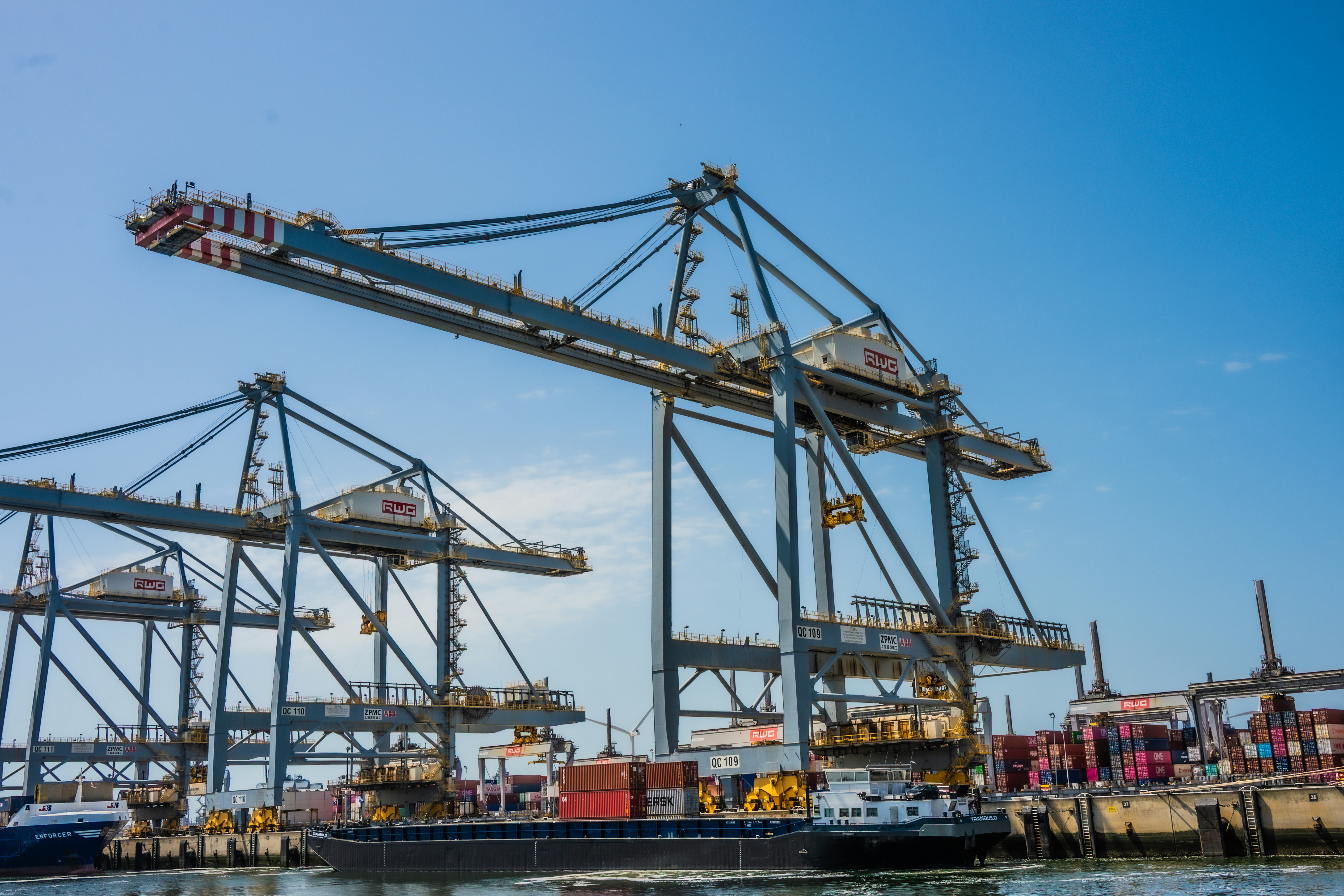 Port cranes loading cargo onto a large vessel