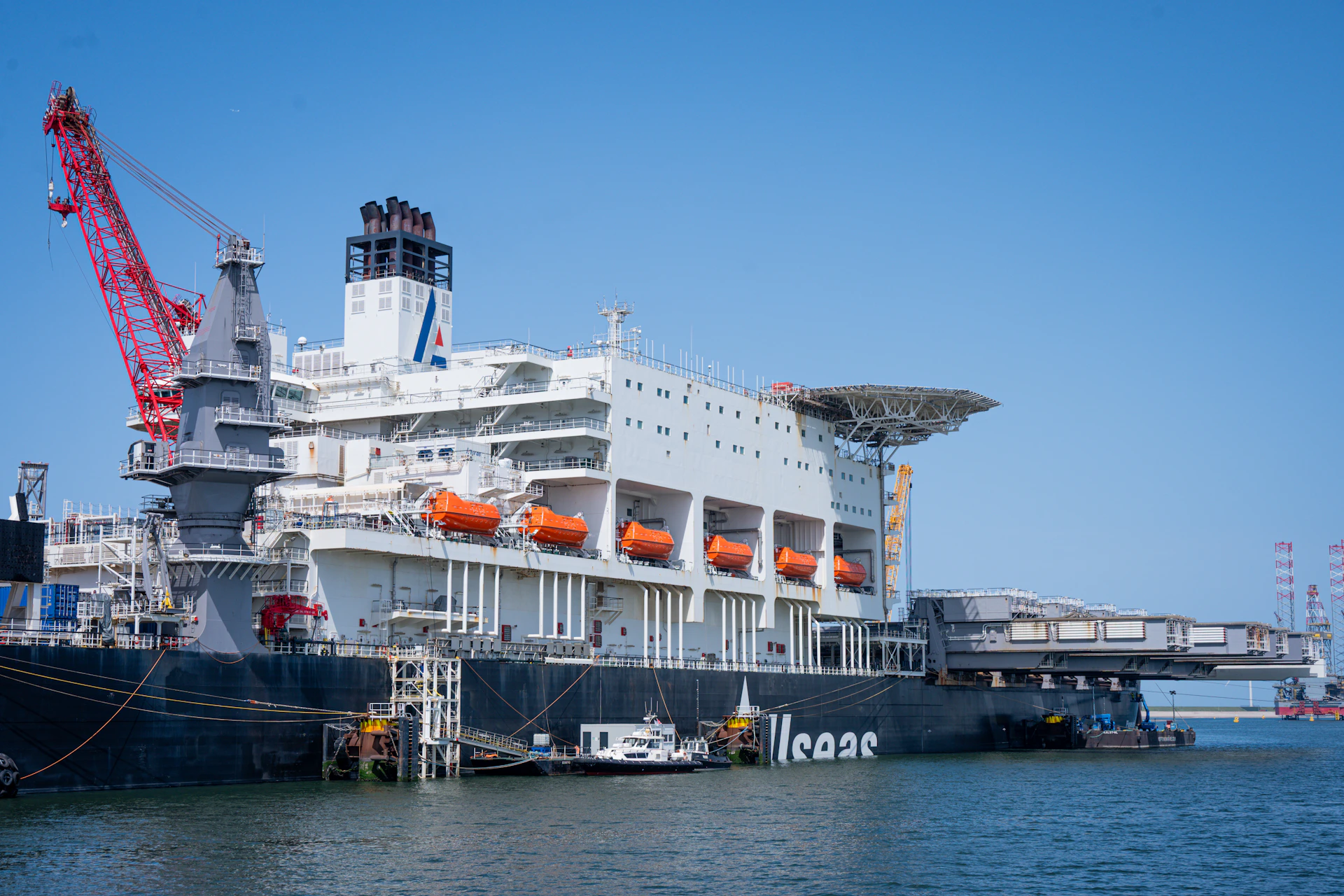 Massive offshore vessel with a red crane and helipad