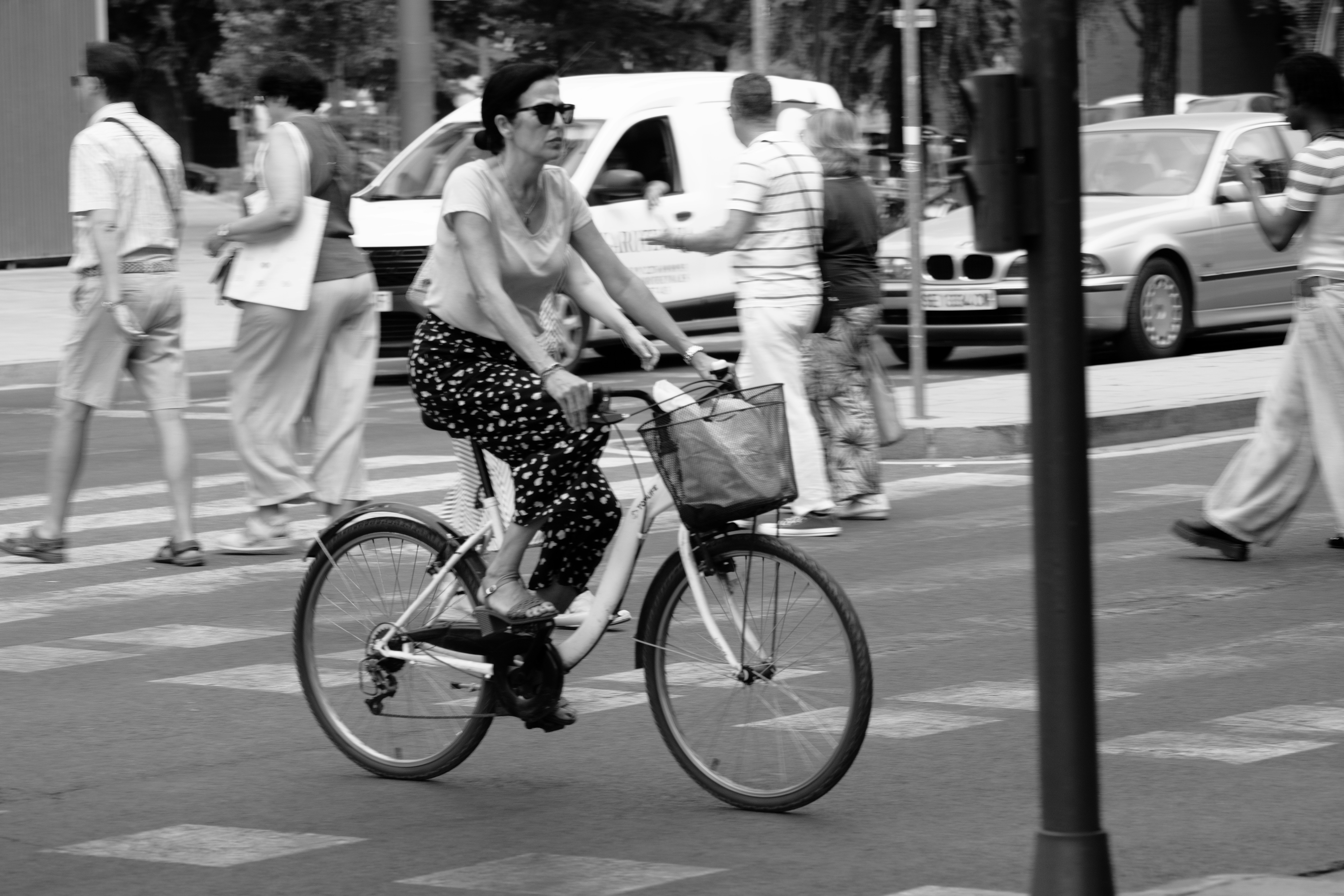 Black and white woman riding a bicycle on a city street