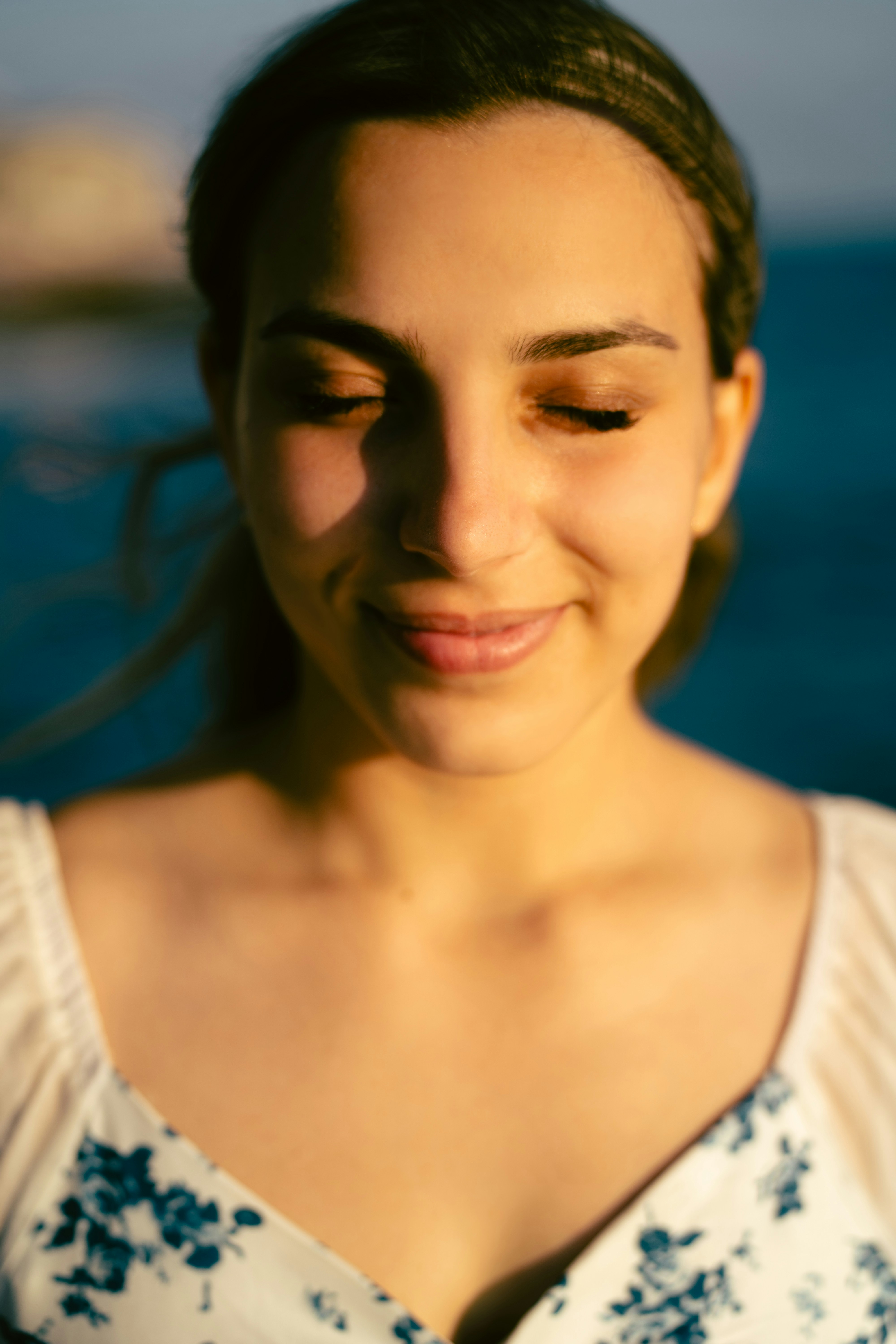 Woman with eyes closed, smiling in golden light