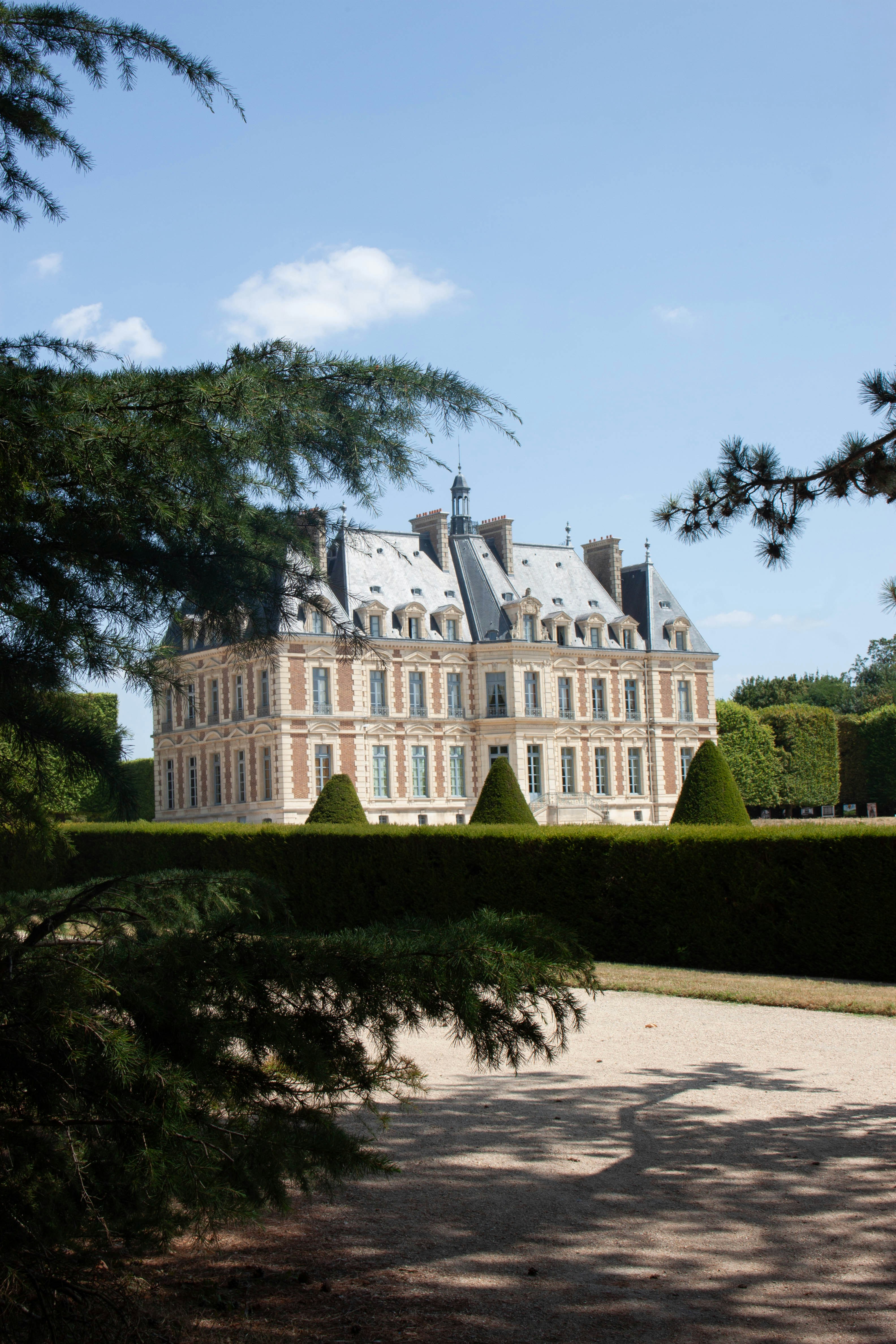 Un grande castello incorniciato da alberi verdi e siepi rigogliosi