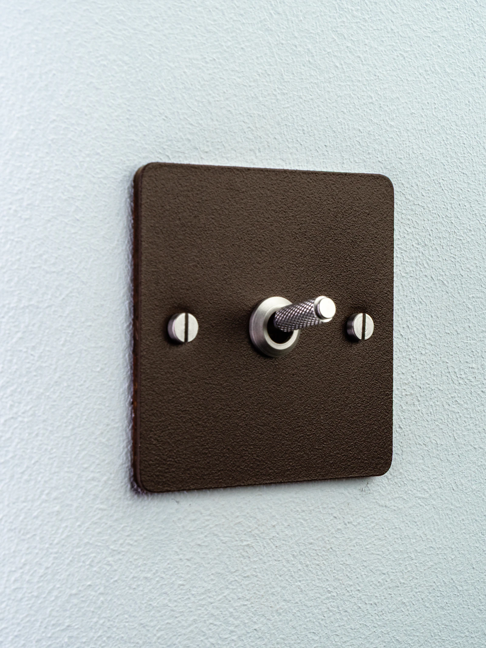 Toggle light switch with a metal lever on a wall plate