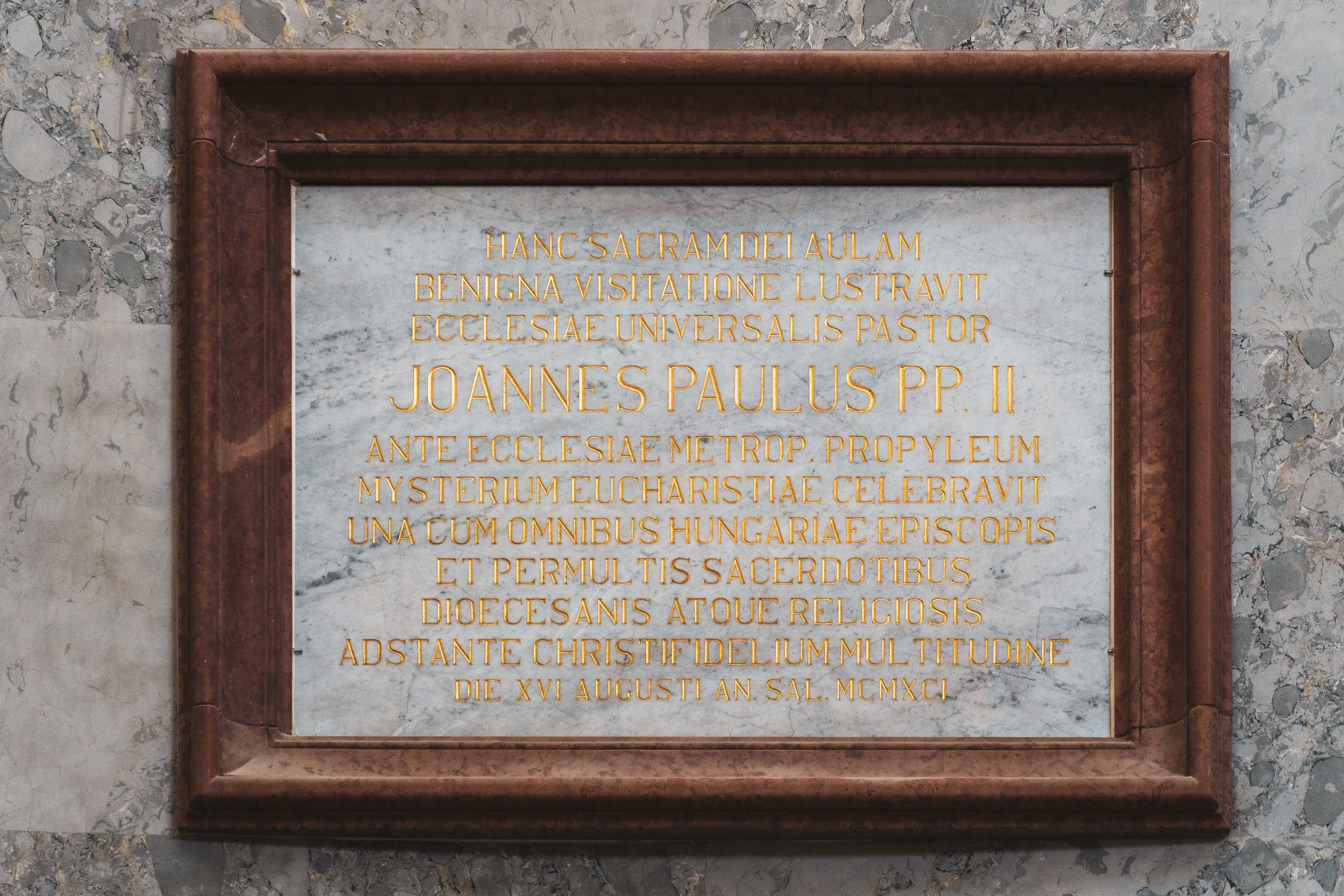 Framed marble plaque with gold text on a wall
