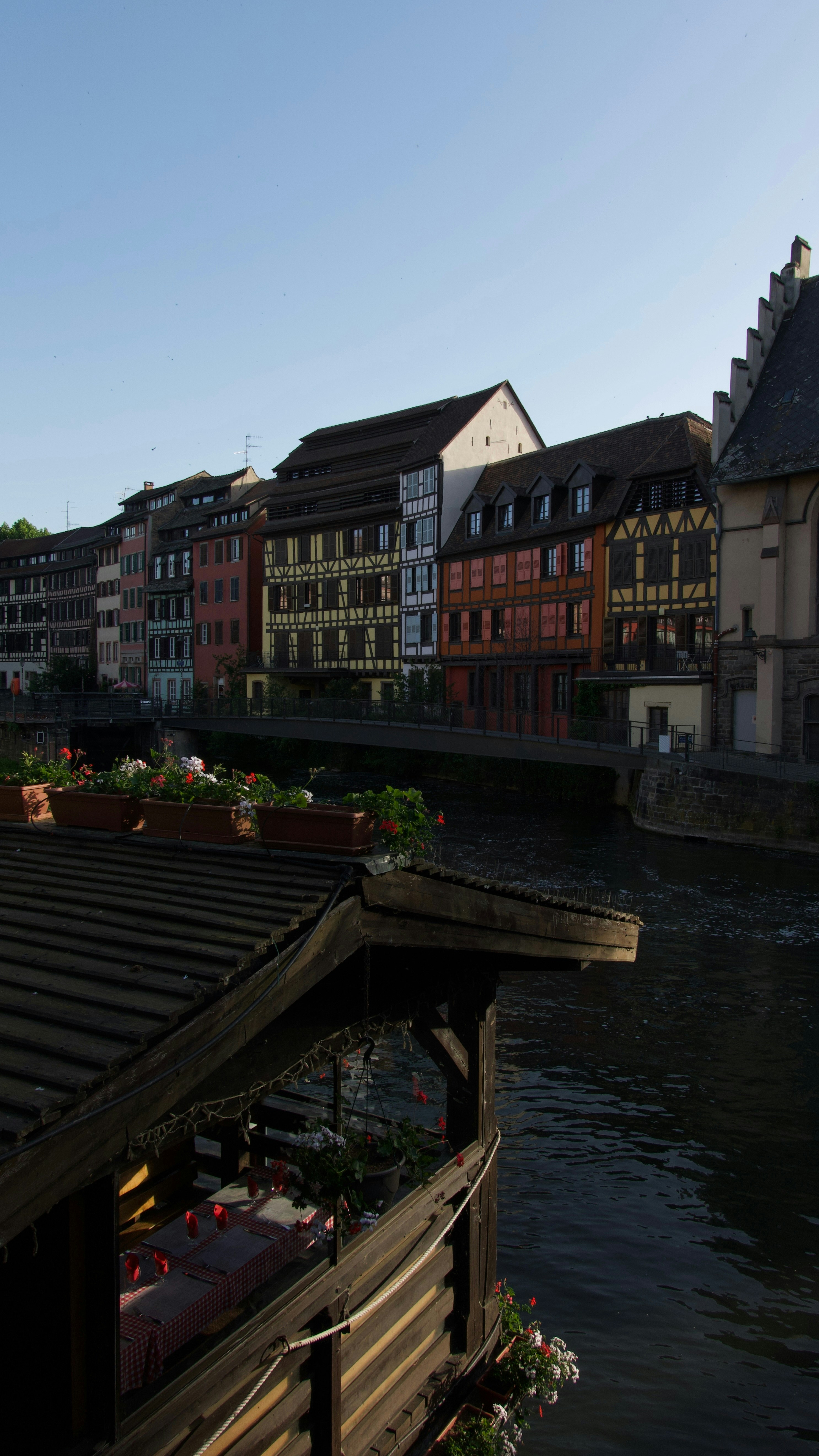 Colorful buildings line a canal with a wooden balcony