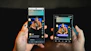 Hands holding two smartphones showing the same video