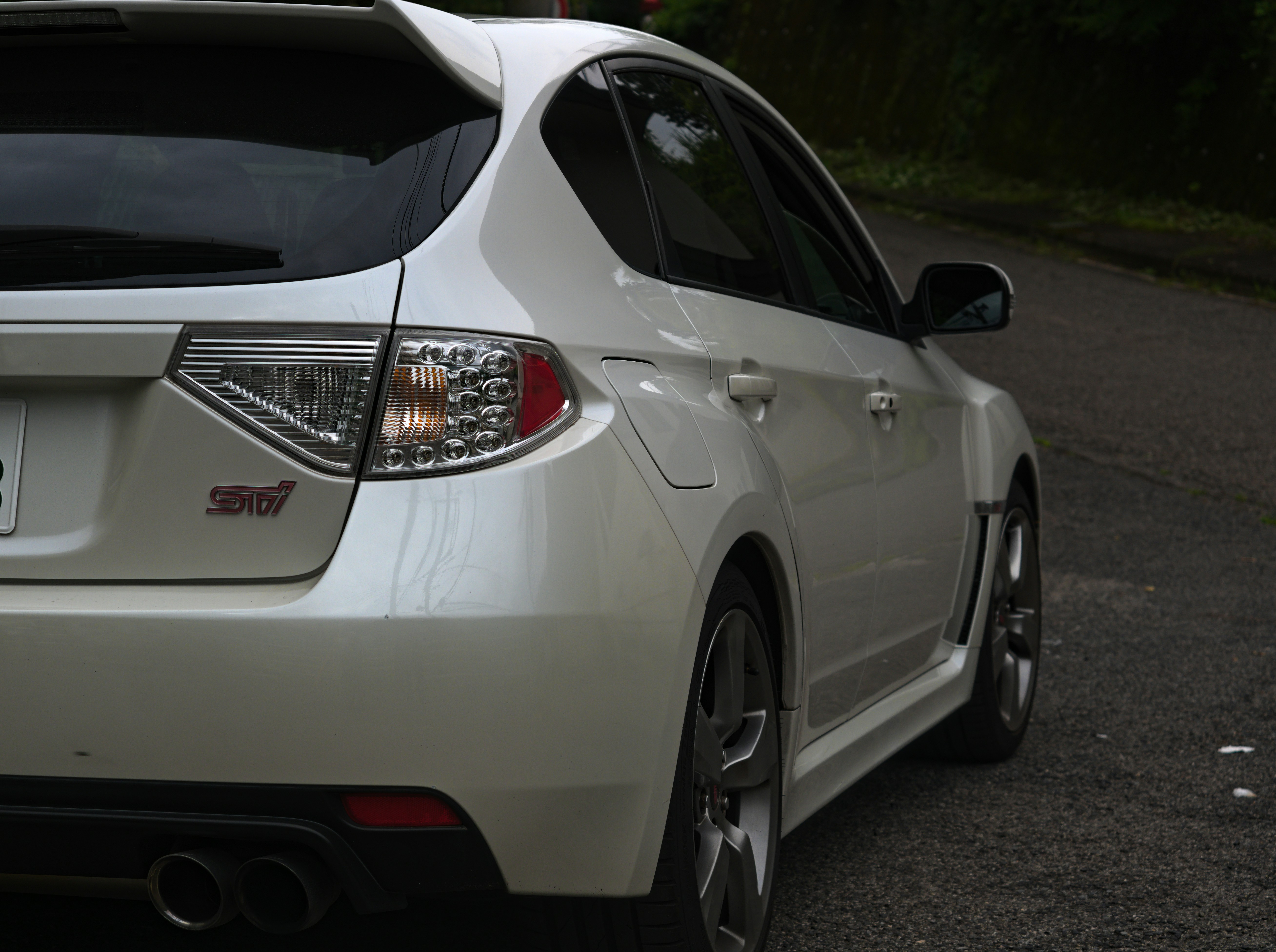 White subaru wrx sti hatchback parked on a road