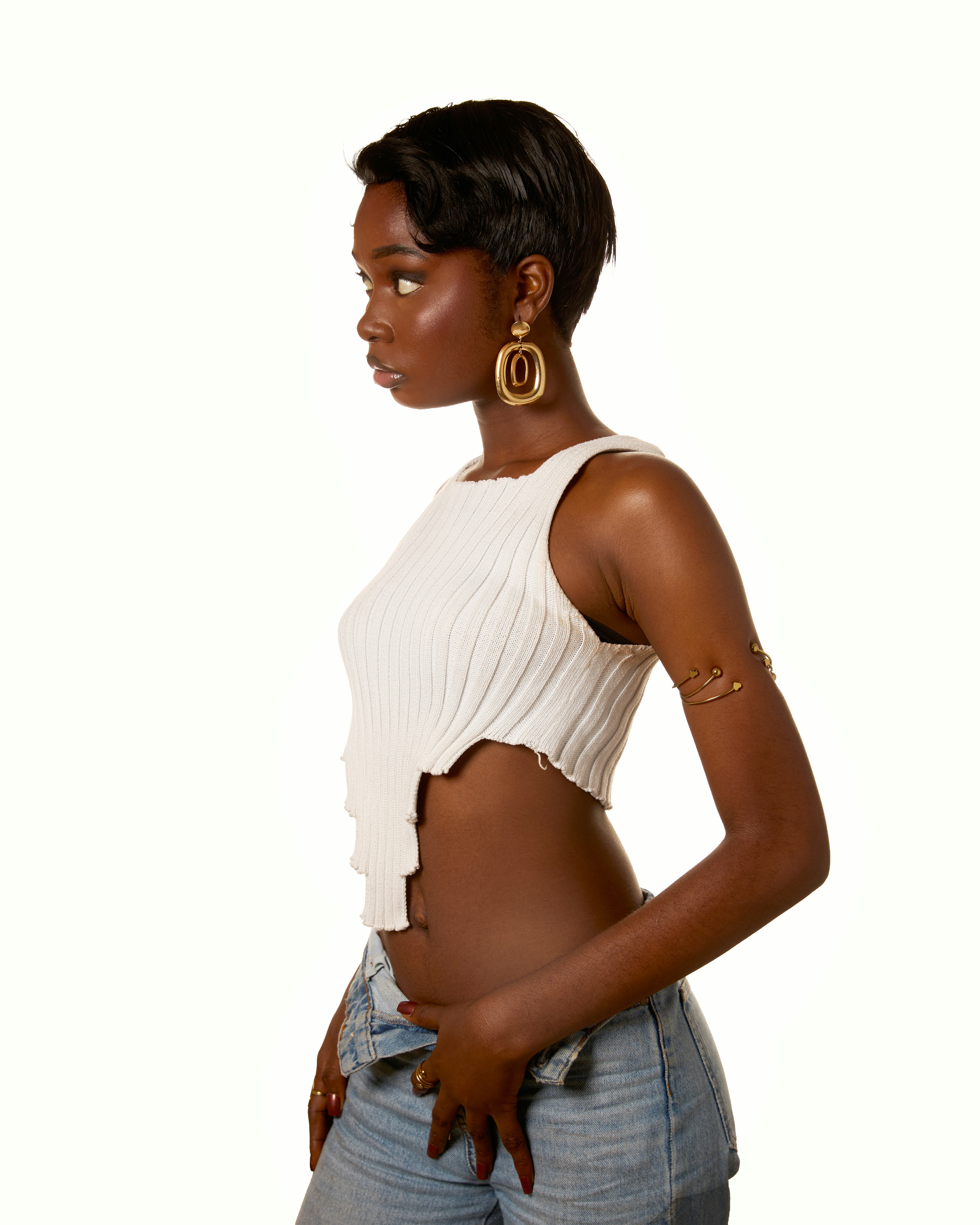Junge schwarze Frau im Profil trägt ein weißes Crop-Top