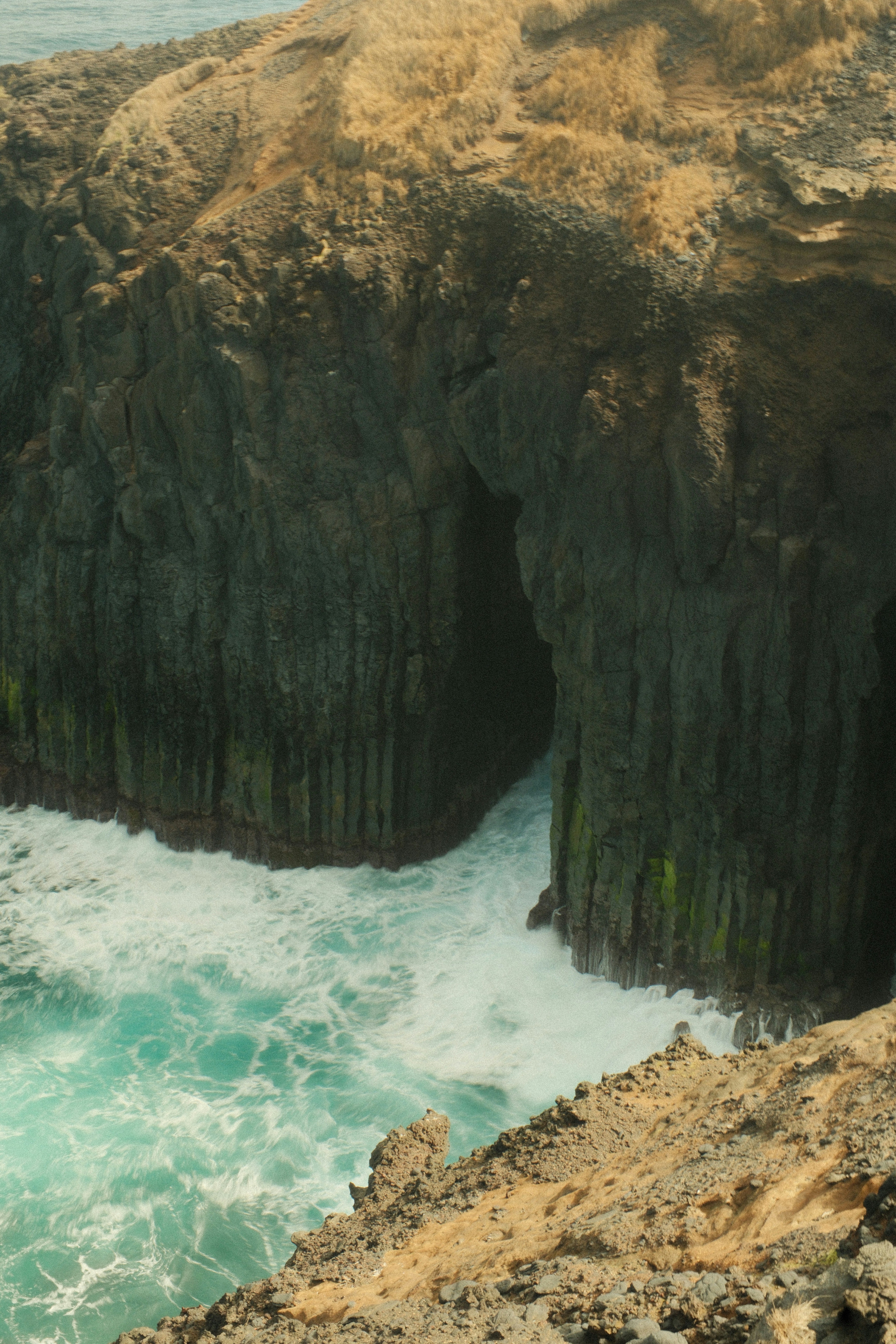 Ocean waves crash into a rugged sea cave