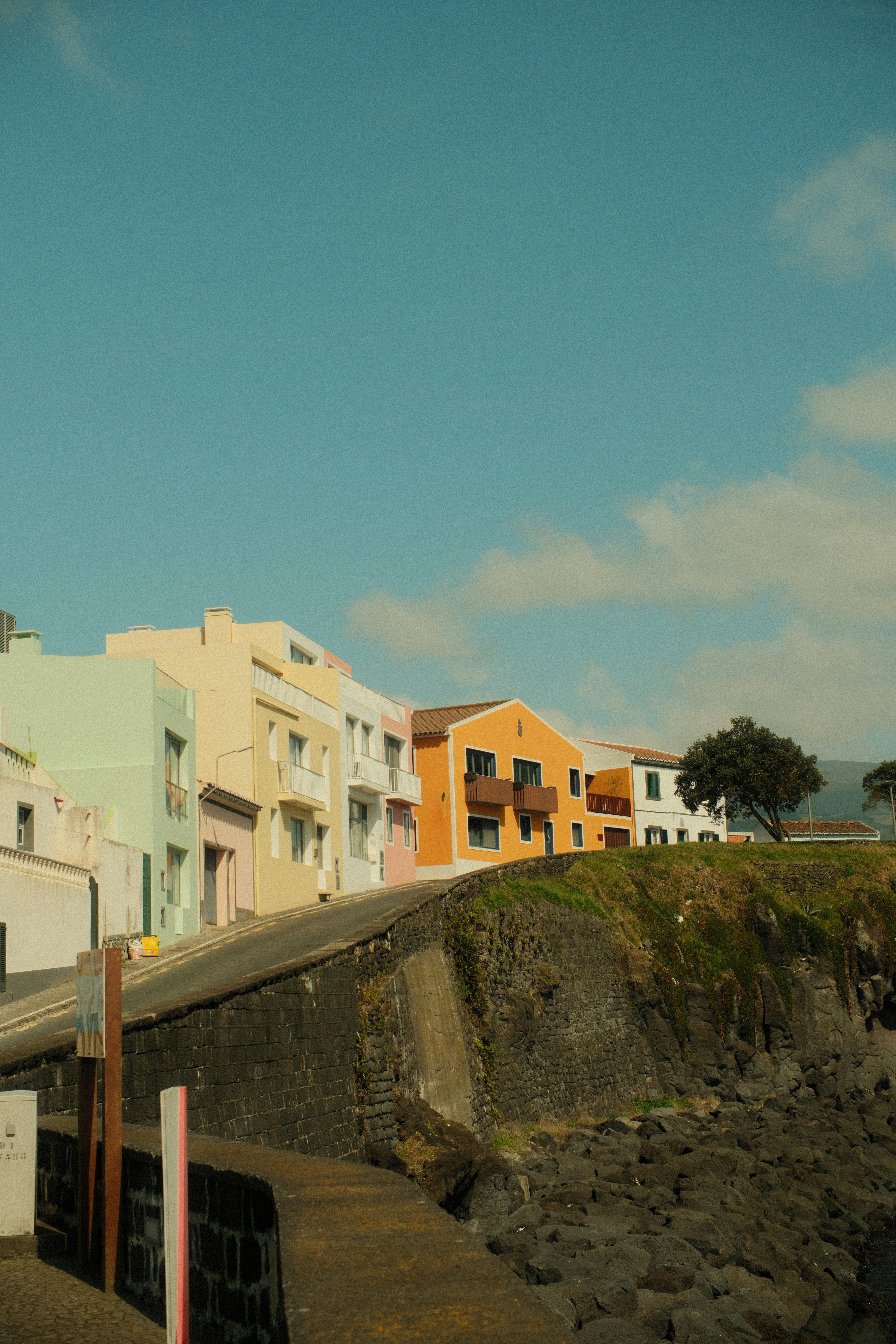 Colorful houses line a cliffside under a clear blue sky