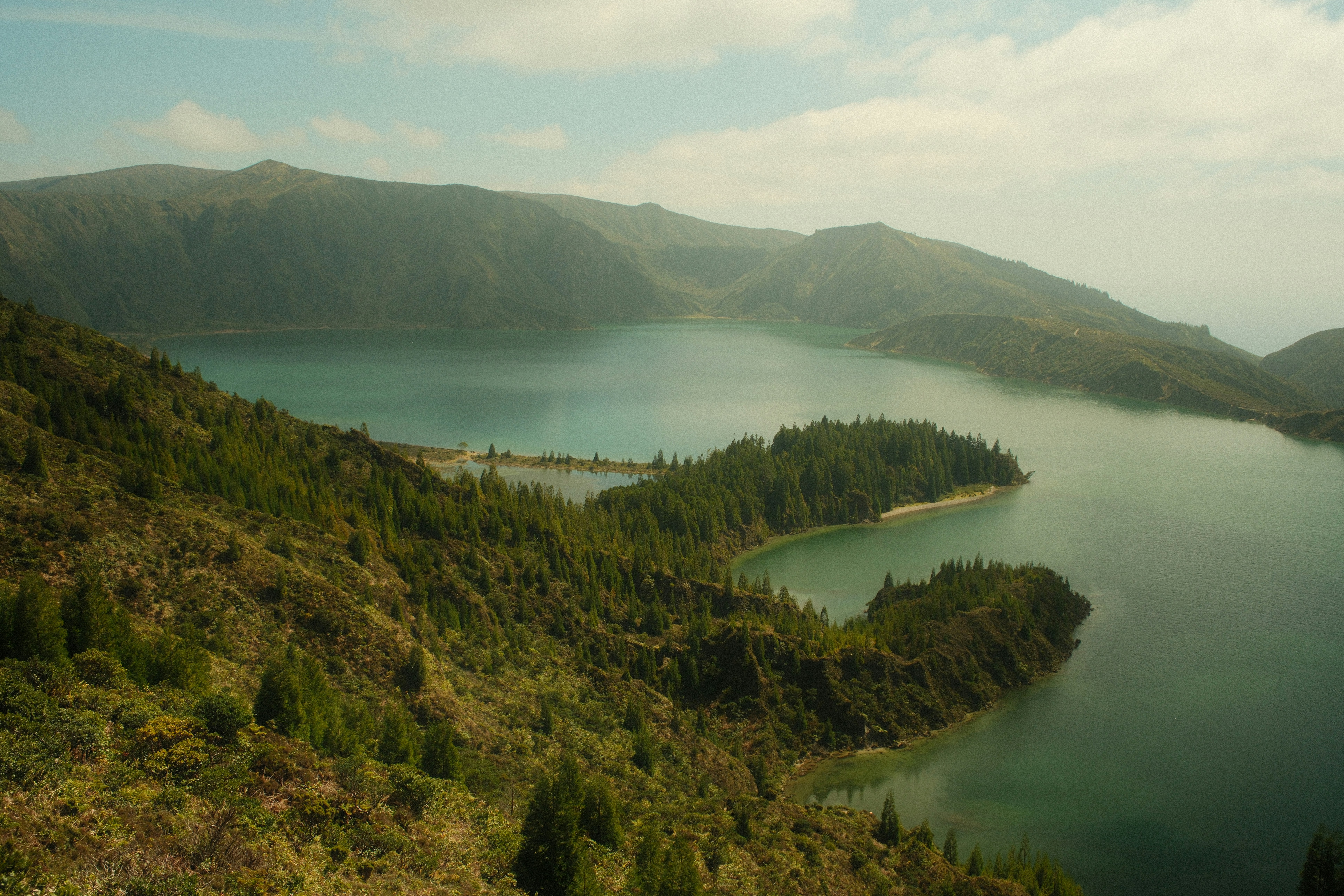 Serene blue lake surrounded by forested hills and mountains