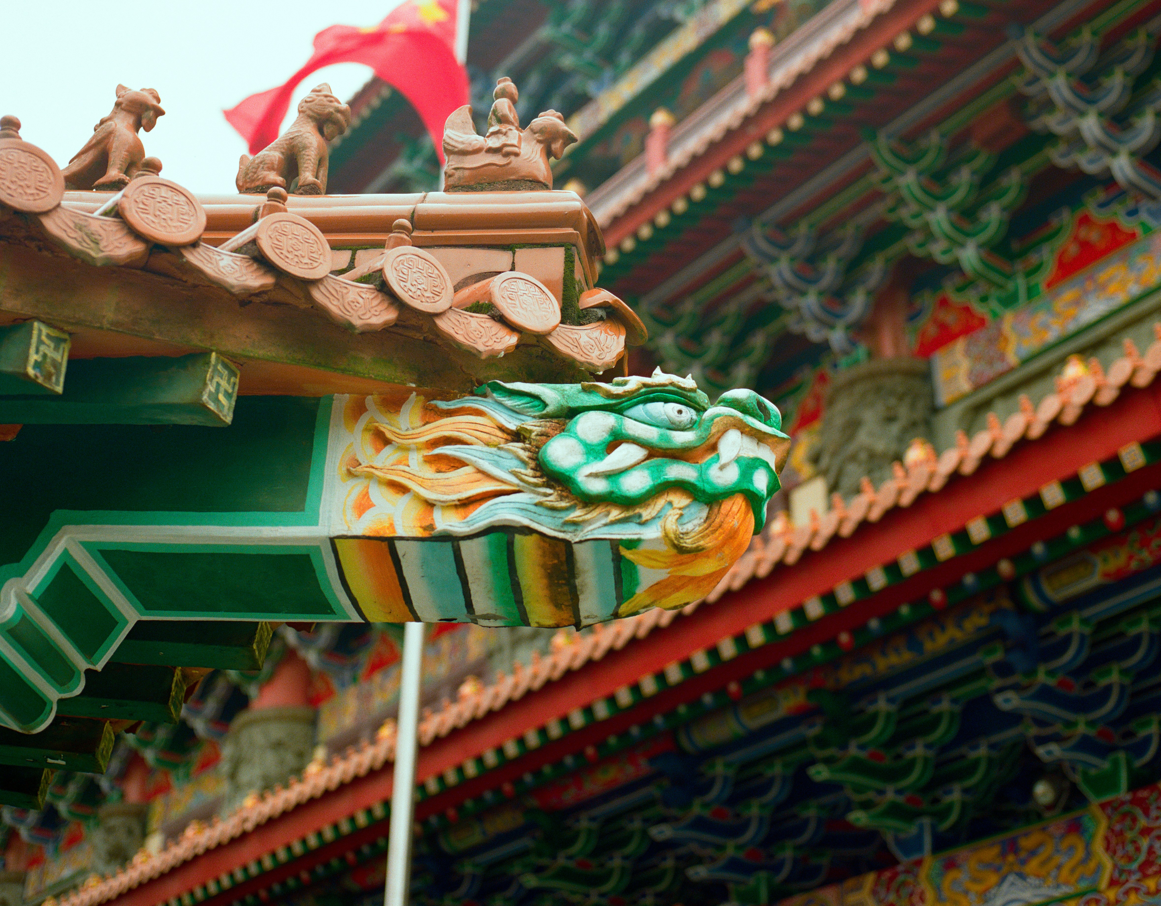 Colorful dragon head sculpture on a traditional asian temple roof