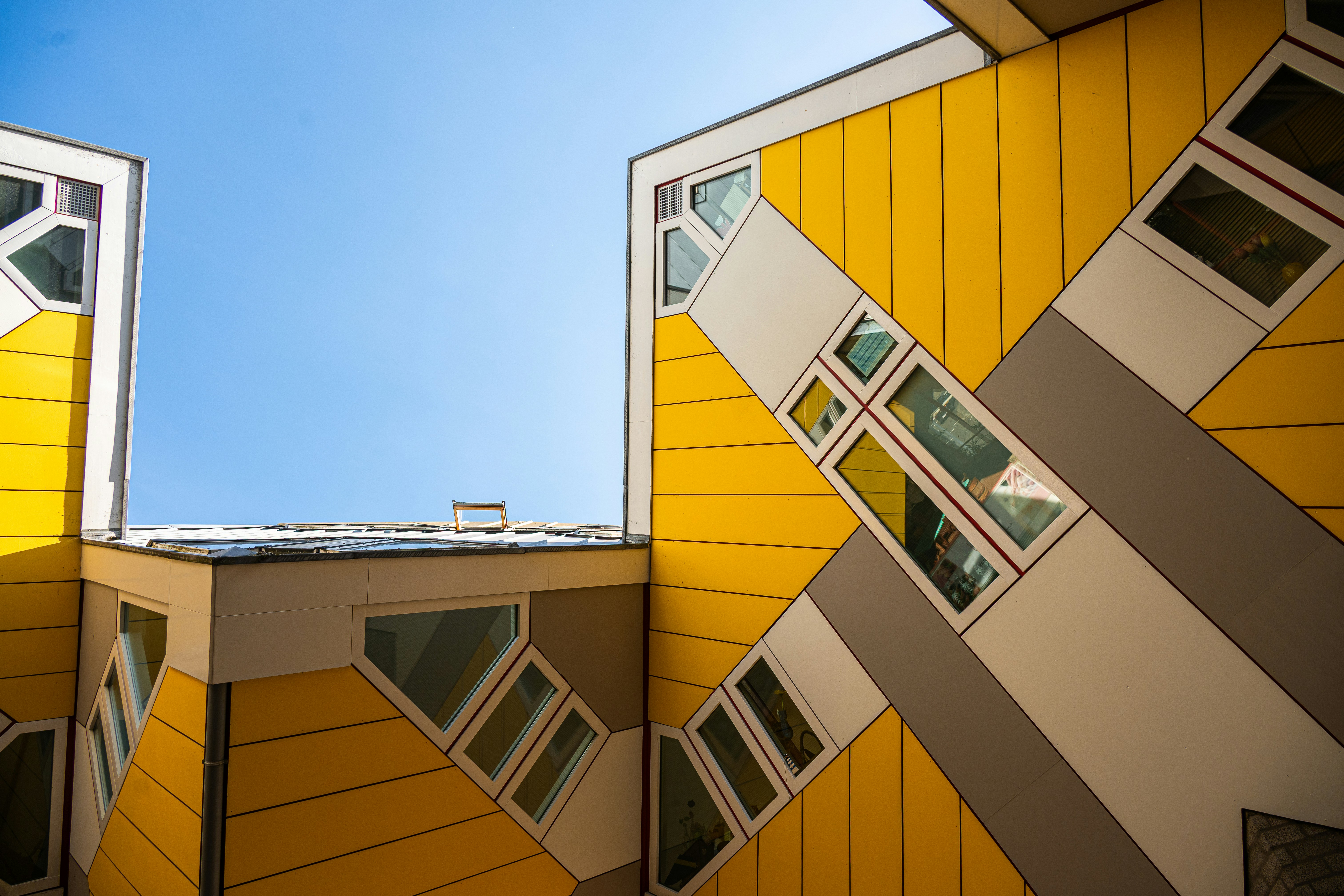 Abstrakter gelber Würfel beherbergt unter einem klaren blauen Himmel.