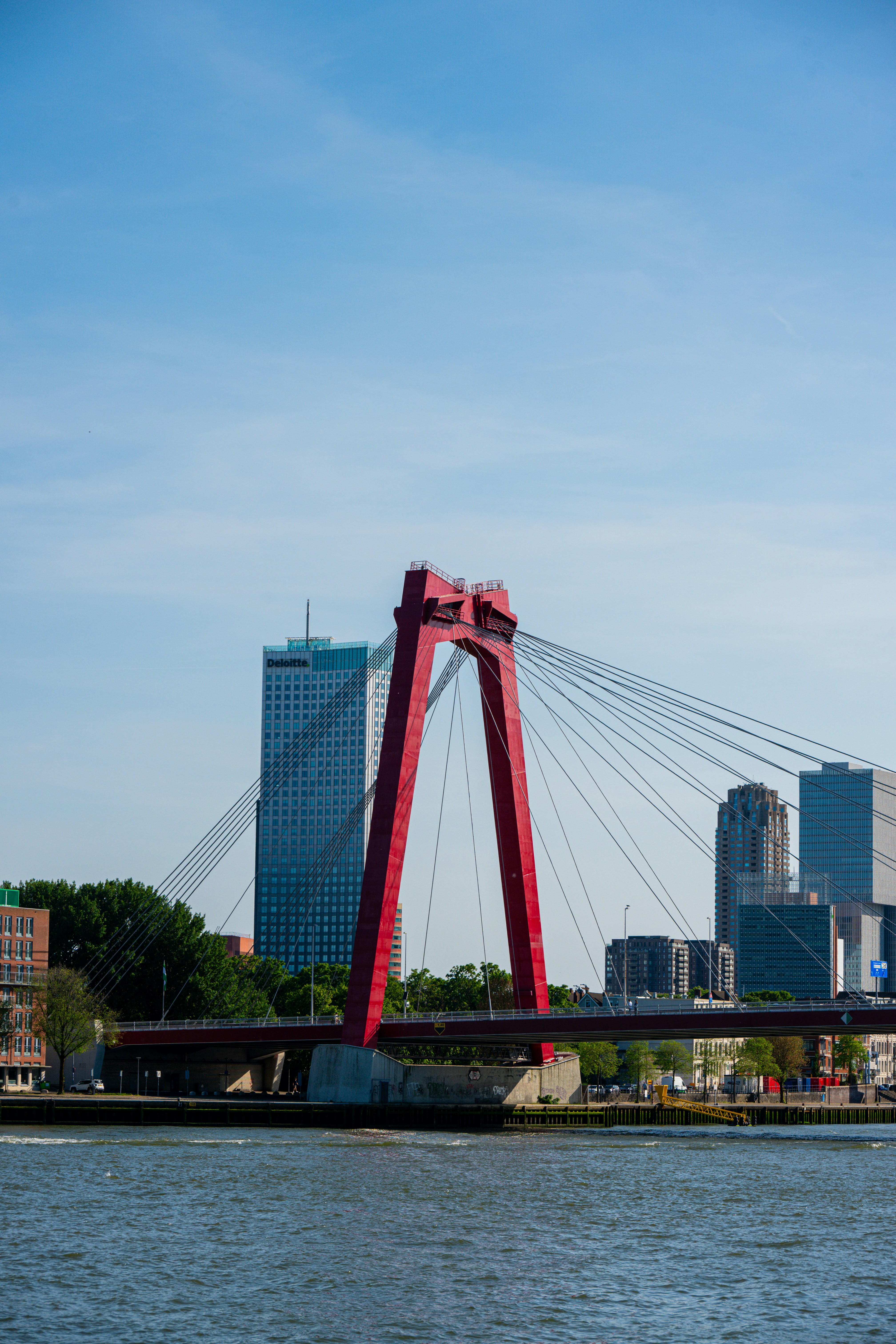 Die ikonische rote Brücke überspannt das Wasser mit moderner Stadtsilhouette.