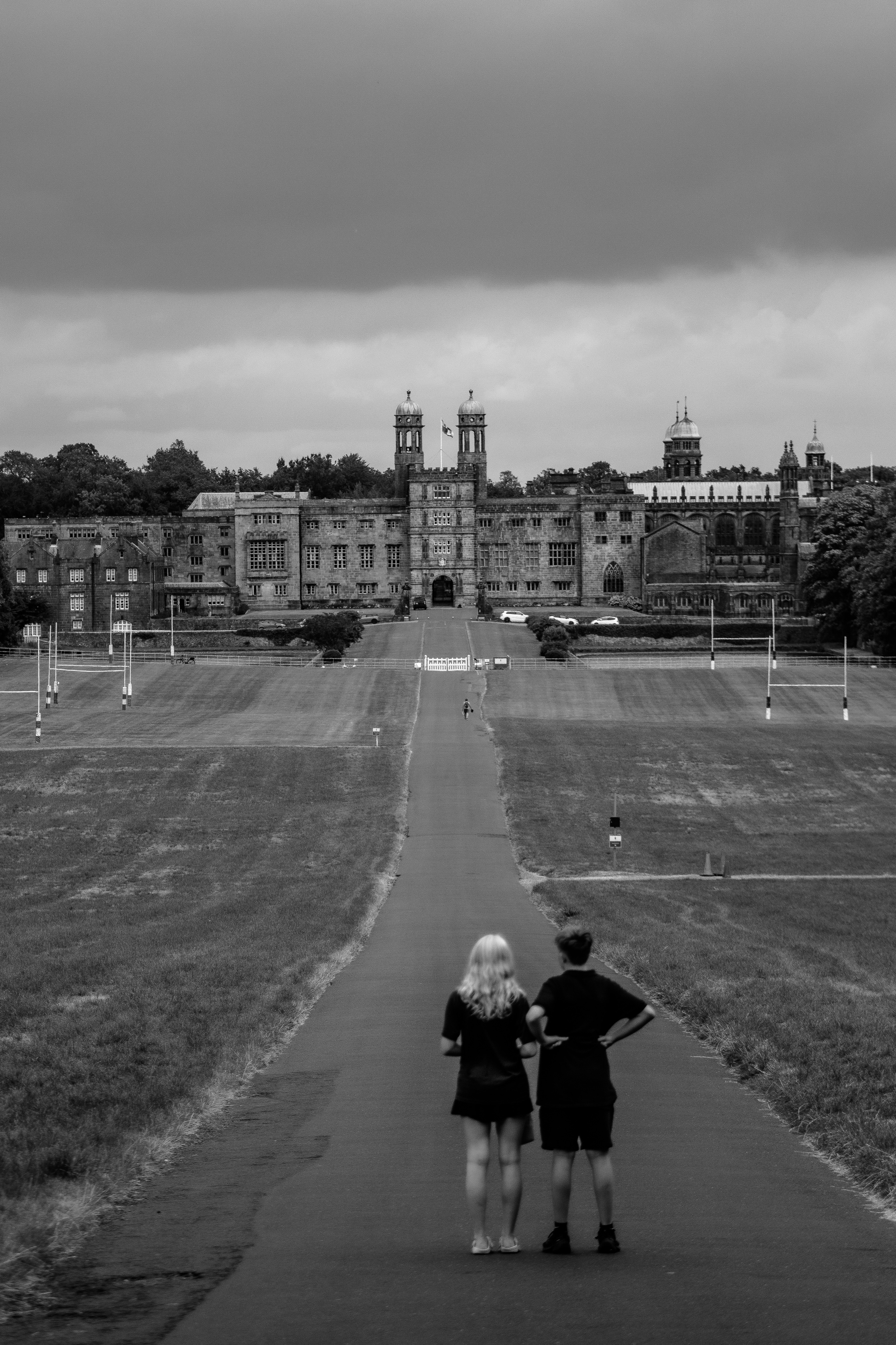 People stand on path looking at majestic building