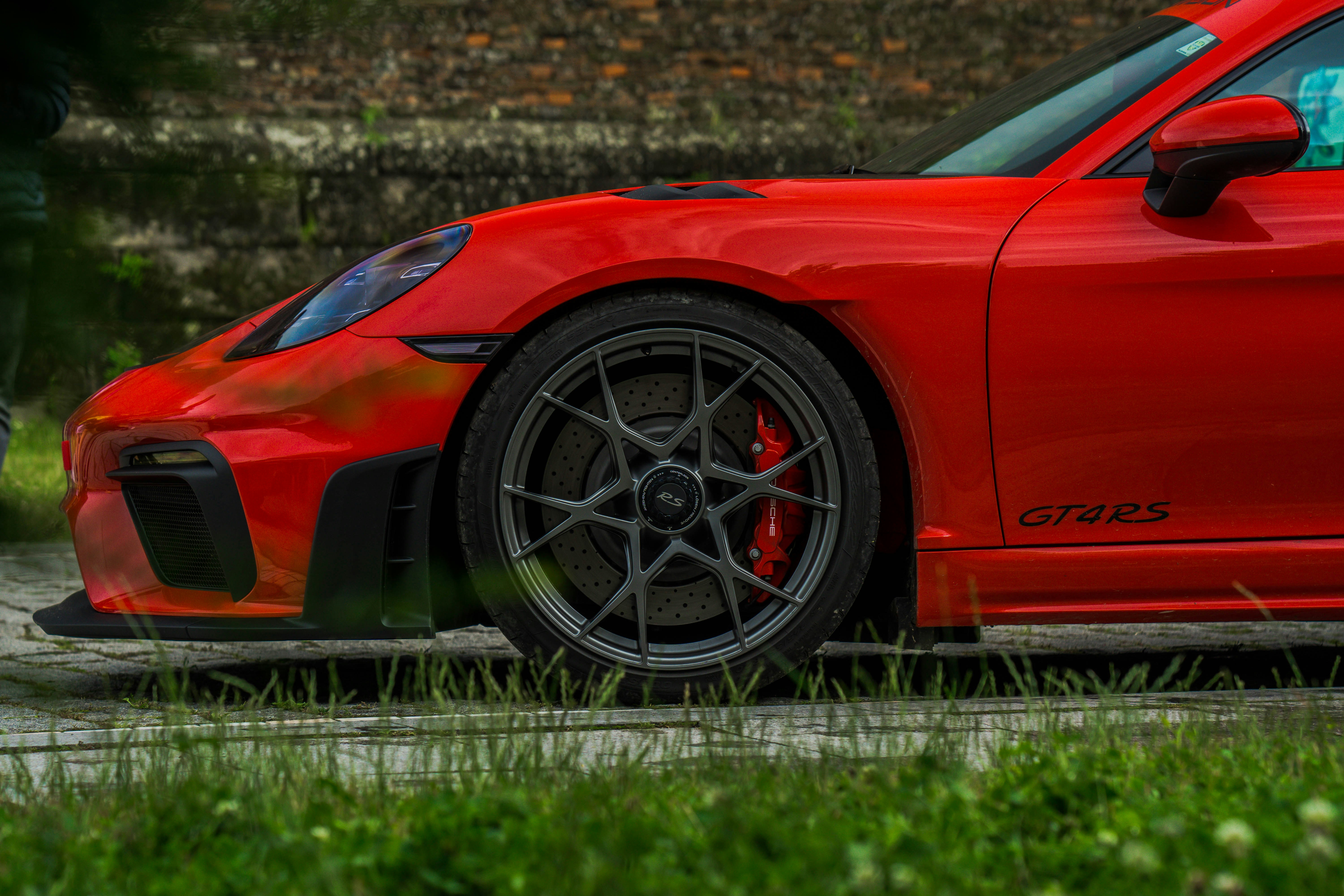 Red porsche sports car parked on green grass