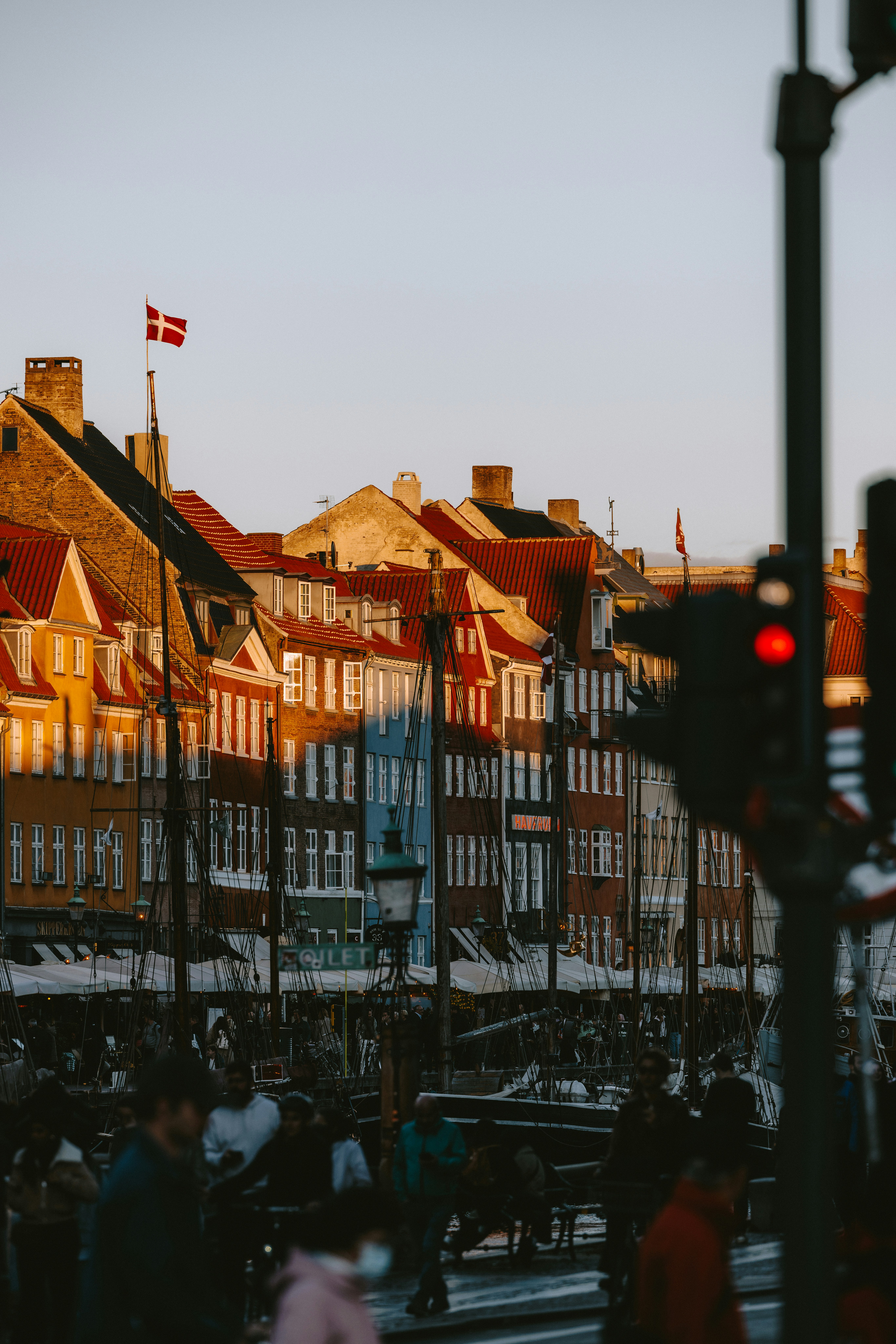 Colorful buildings and people along a canal at sunset