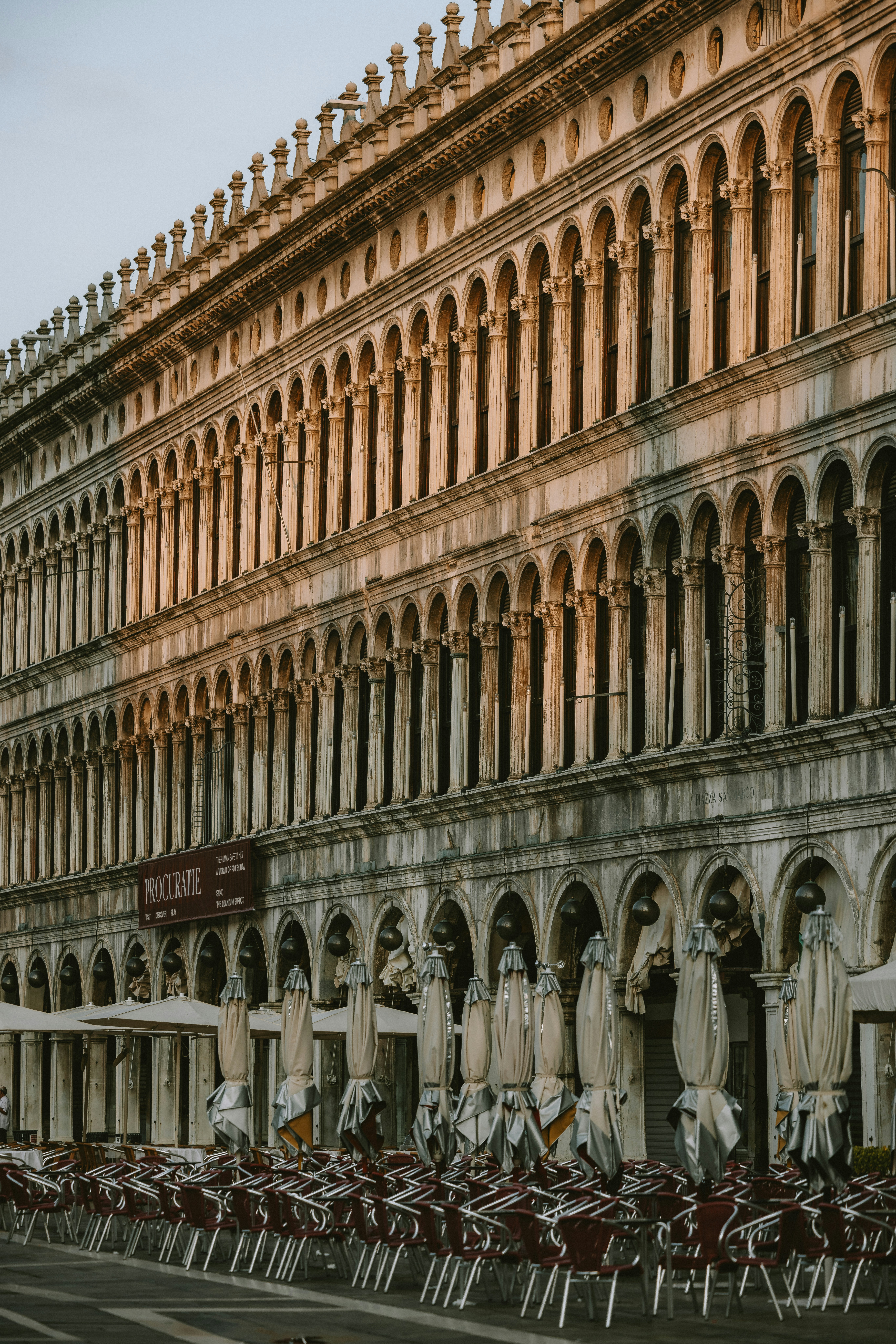 Elegant building with arcades, columns, and an outdoor cafe setup