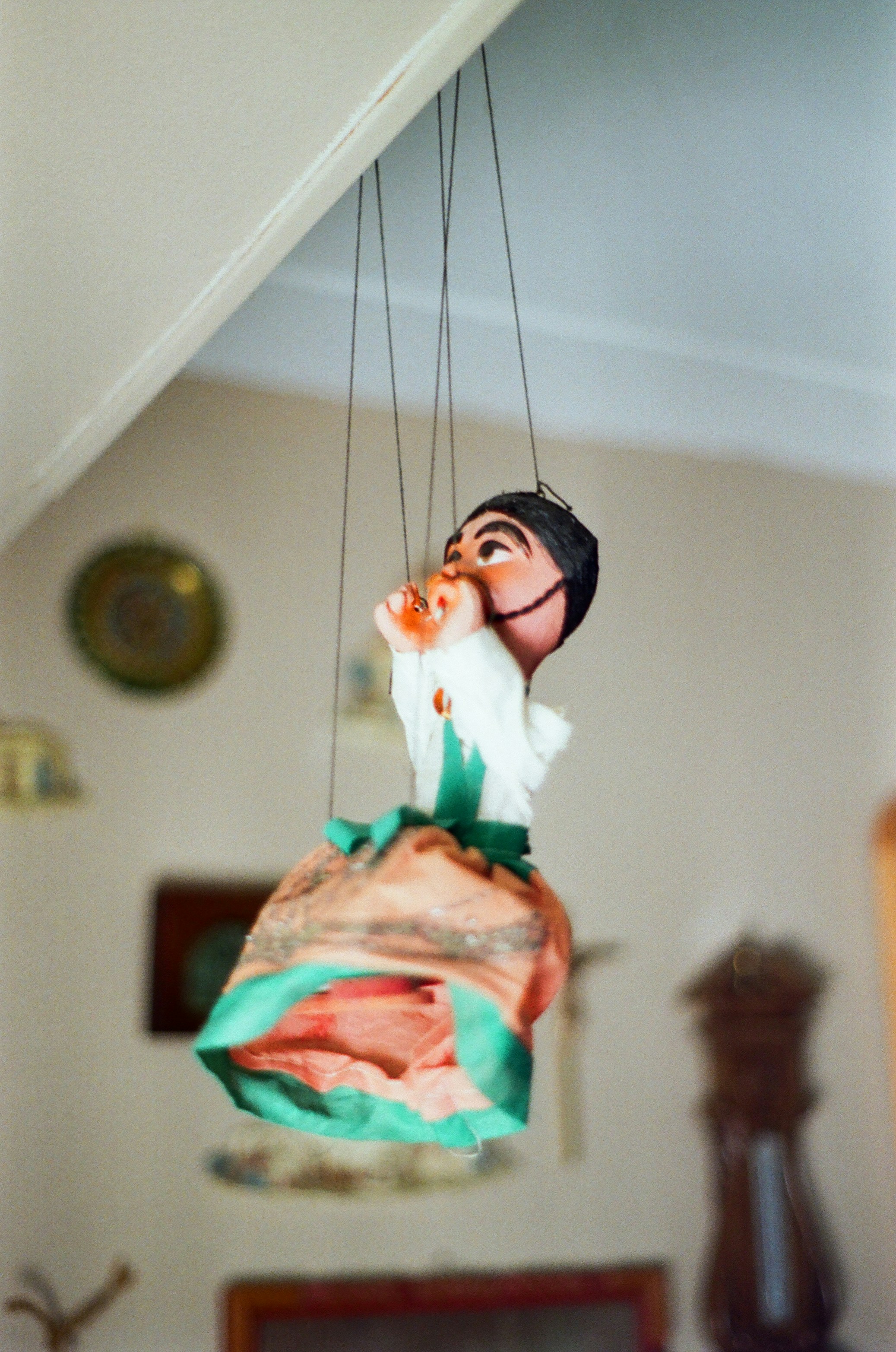 A traditional puppet hangs from the ceiling by strings