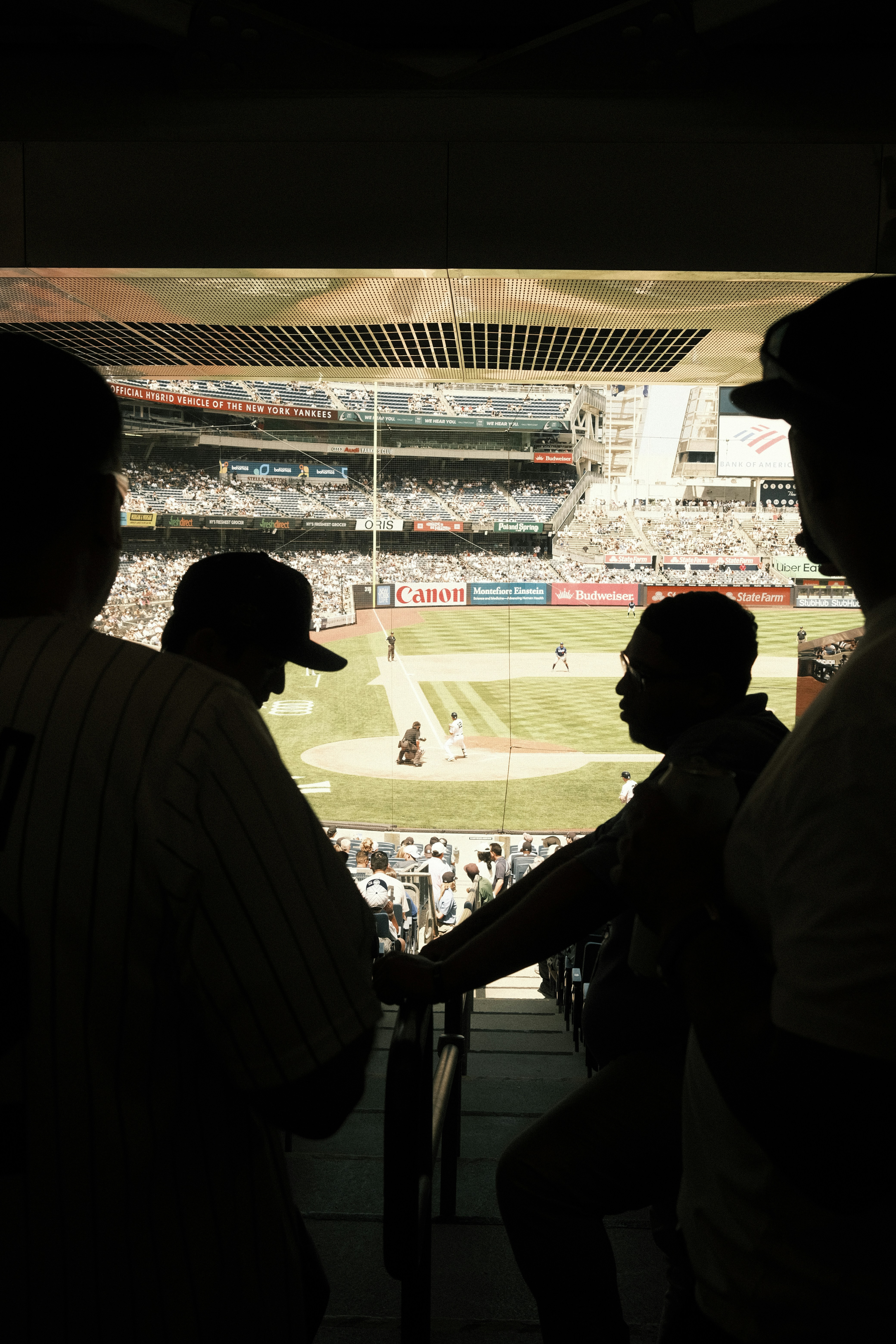 Silhouetted fans watch a baseball game from stadium seats. - 相关推荐
